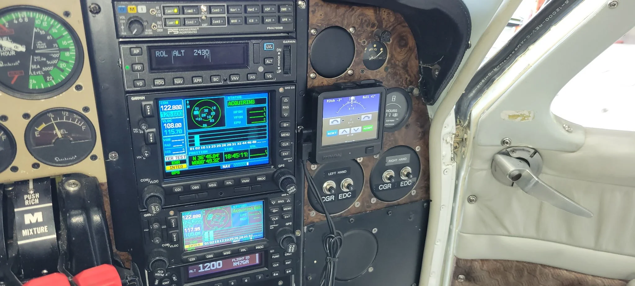Close-up of aircraft cockpit instruments and avionics panels, including gauges, switches, and digital displays.