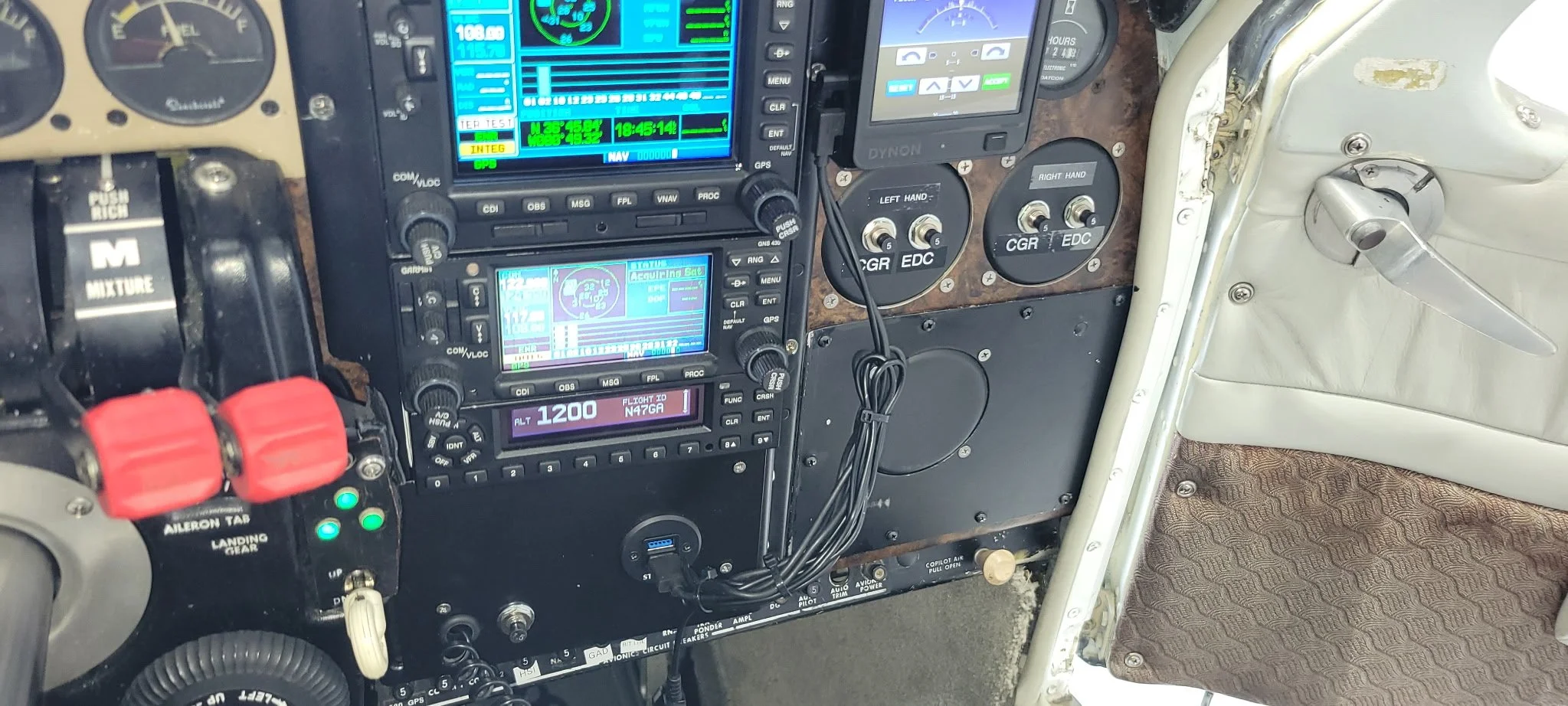 Aircraft cockpit instrument panel with navigation and communication devices, switches, and a control yoke.