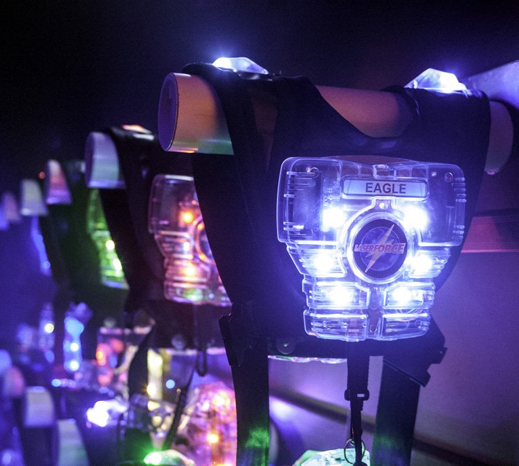 Lunar module trainers with glowing LED lights and labels like 'EAGLE' and 'Laserforce' in a dark room.