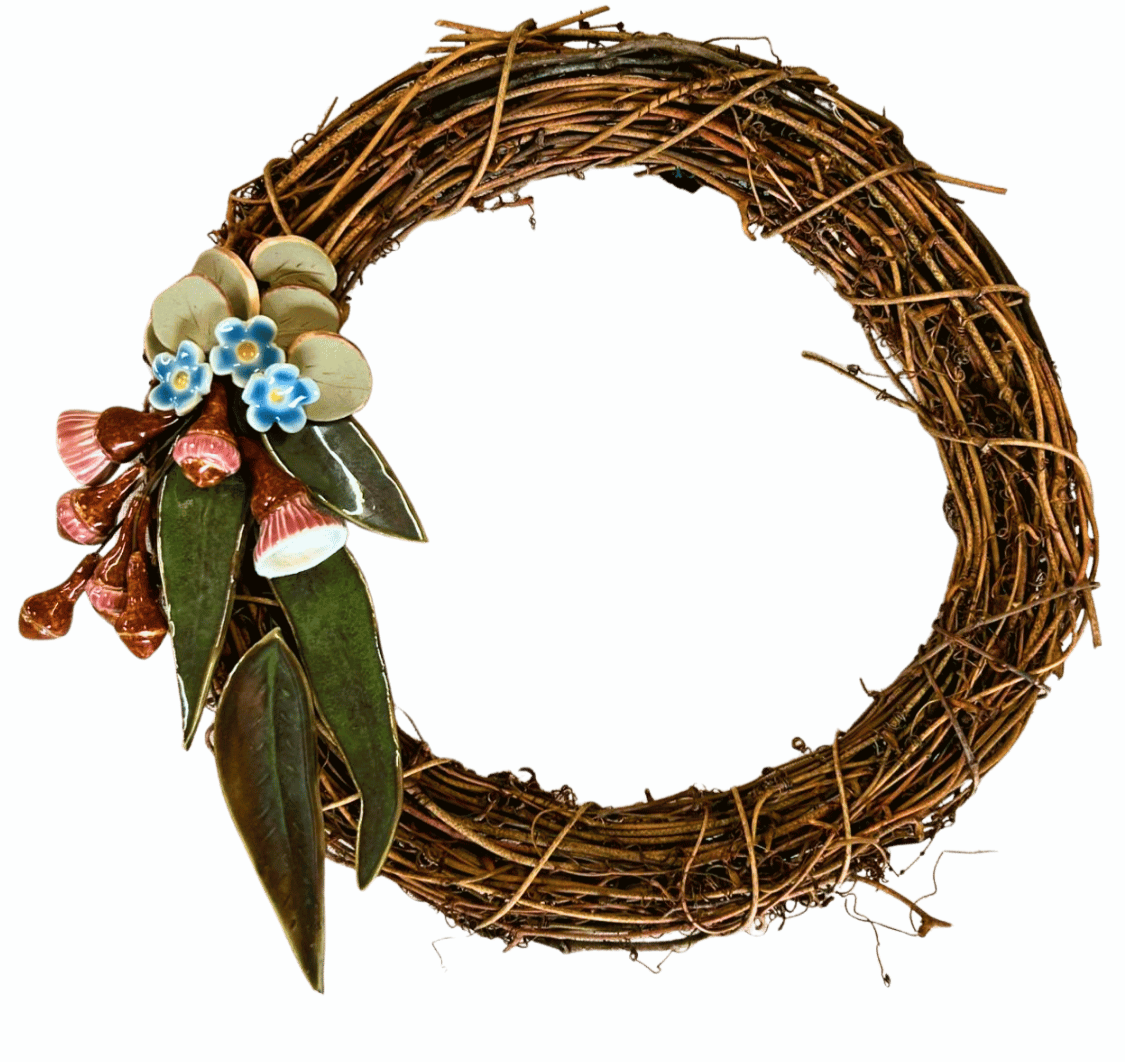 Decorative wreath made of brown twigs with artificial flowers and leaves on the left side, set against a teal background.