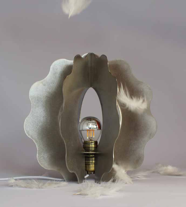 Une lampe à filament électrique encadrée par des plumes et une structure en forme de coquille