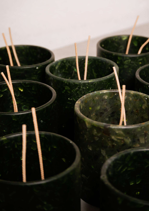 Vases en verre de couleur verte avec des bâtonnets en bois à l'intérieur.