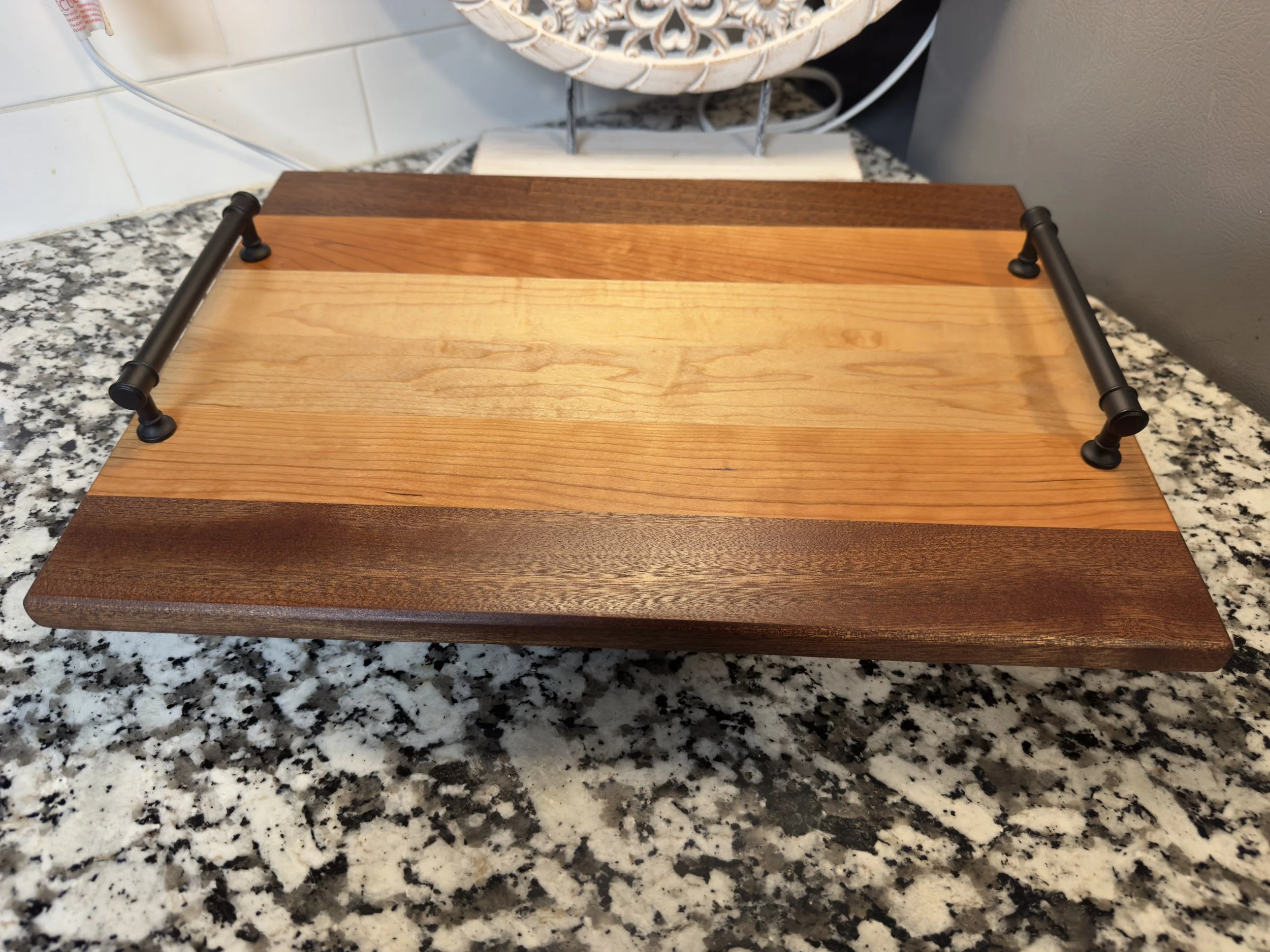 Second striped wooden board fitted with black serving handles