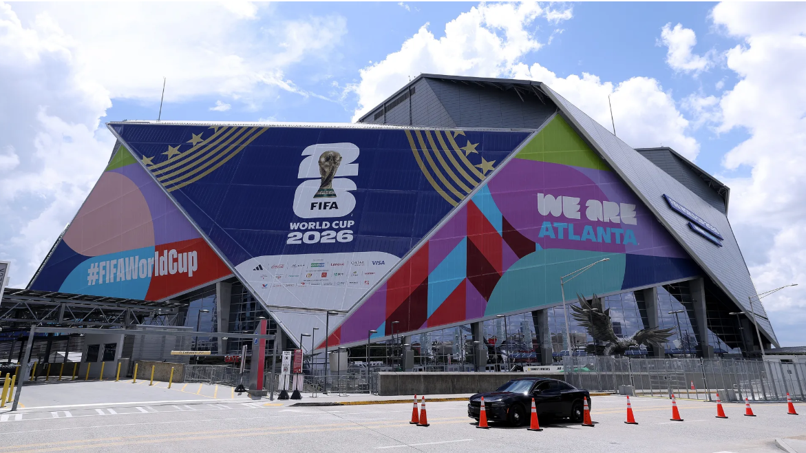 Exterior of a modern stadium with colorful banners promoting the FIFA World Cup 2026 and Atlanta.