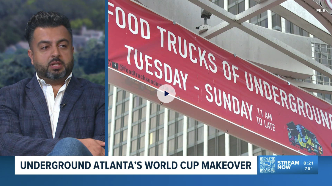 Television news segment discussing Atlanta's underground food trucks, with a man speaking and a red banner advertising food trucks underground on Tuesdays and Sundays from 11 AM to late, featuring a colorful food truck illustration.