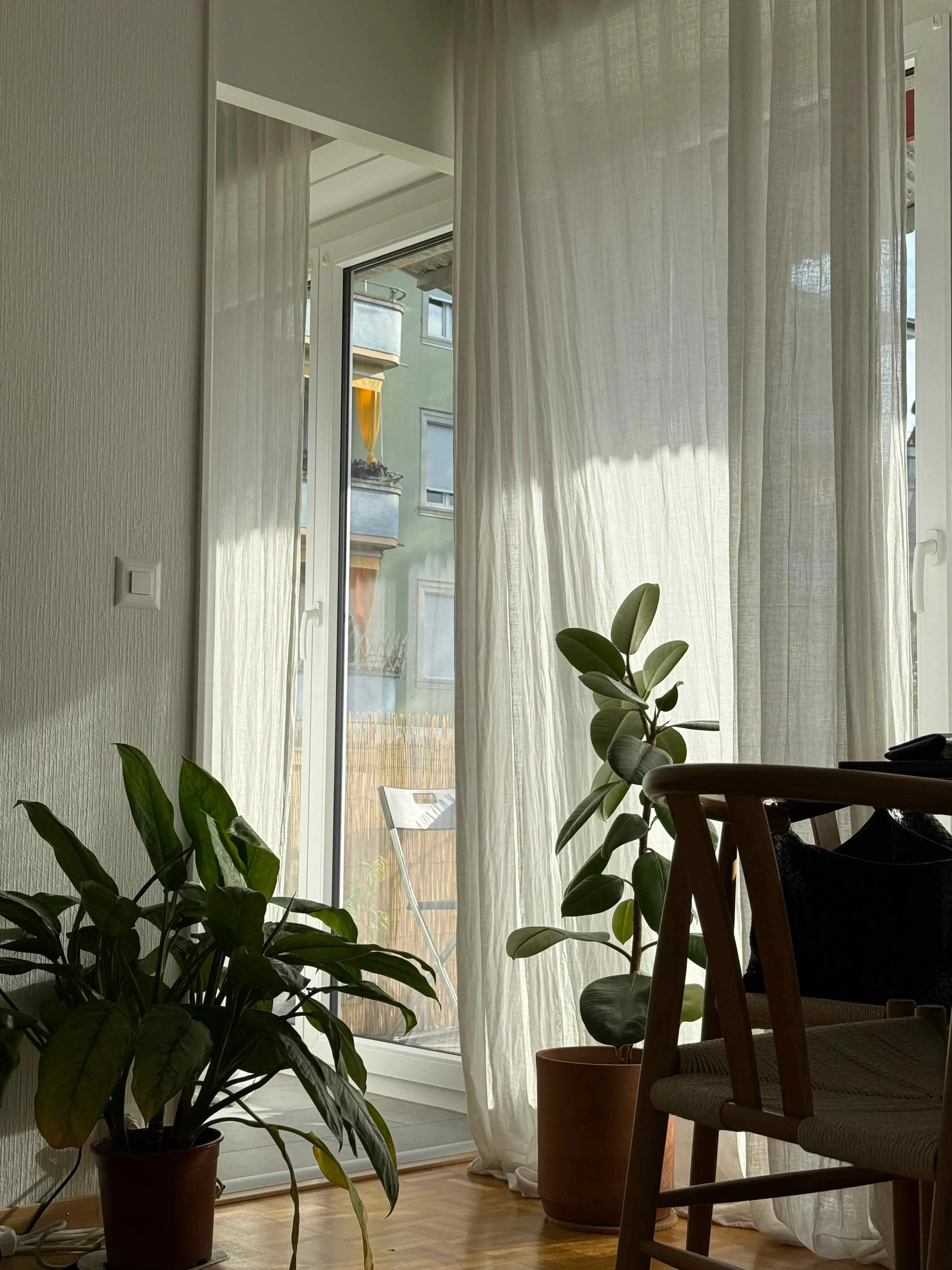 Intérieur lumineux avec rideaux légers, plantes et lumière naturelle