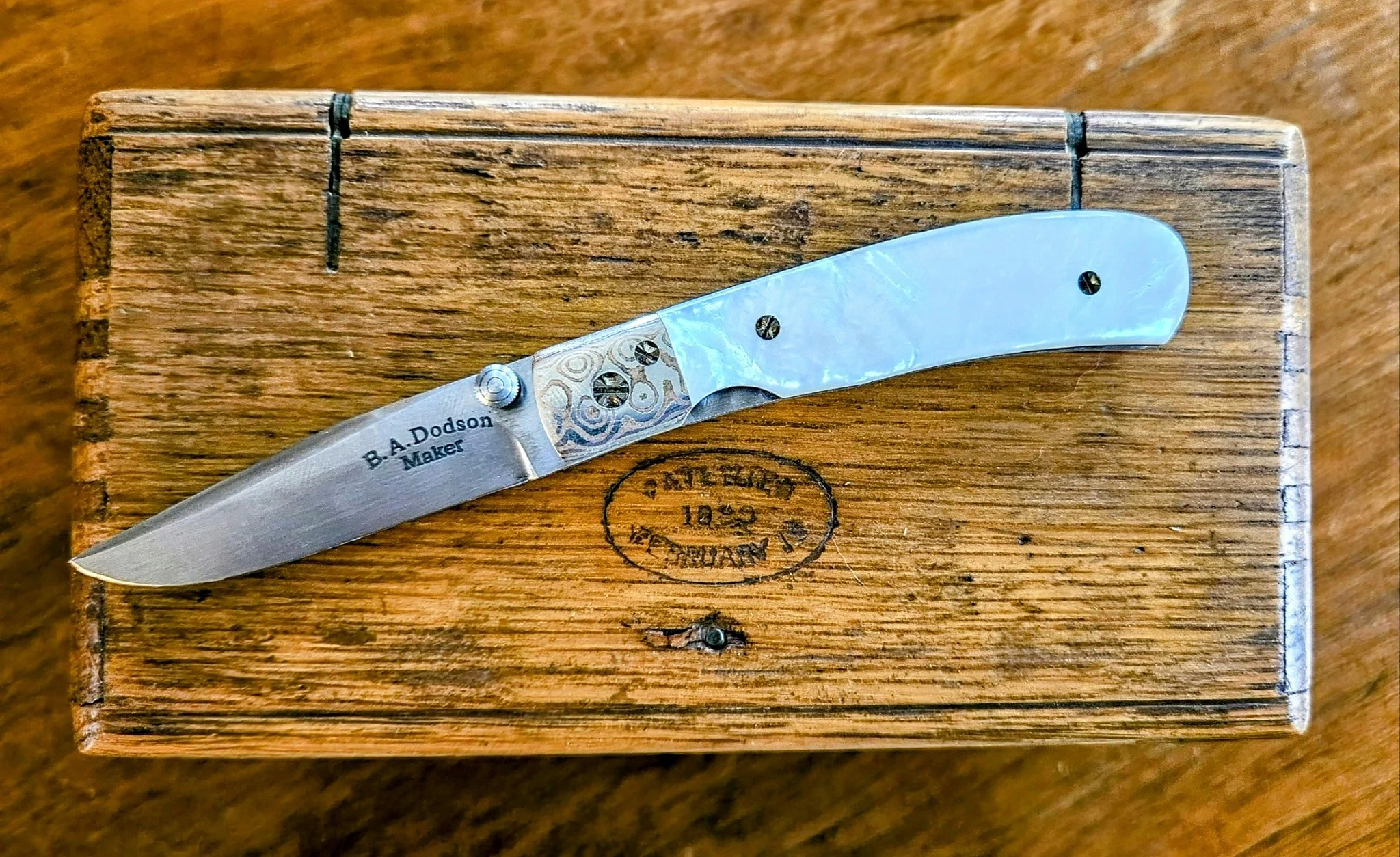 Dodson mother-of-pearl and Mokume liner-lock folder opposite-side detail showing the maker’s mark, Mokume bolster, and iridescent mother-of-pearl handle.