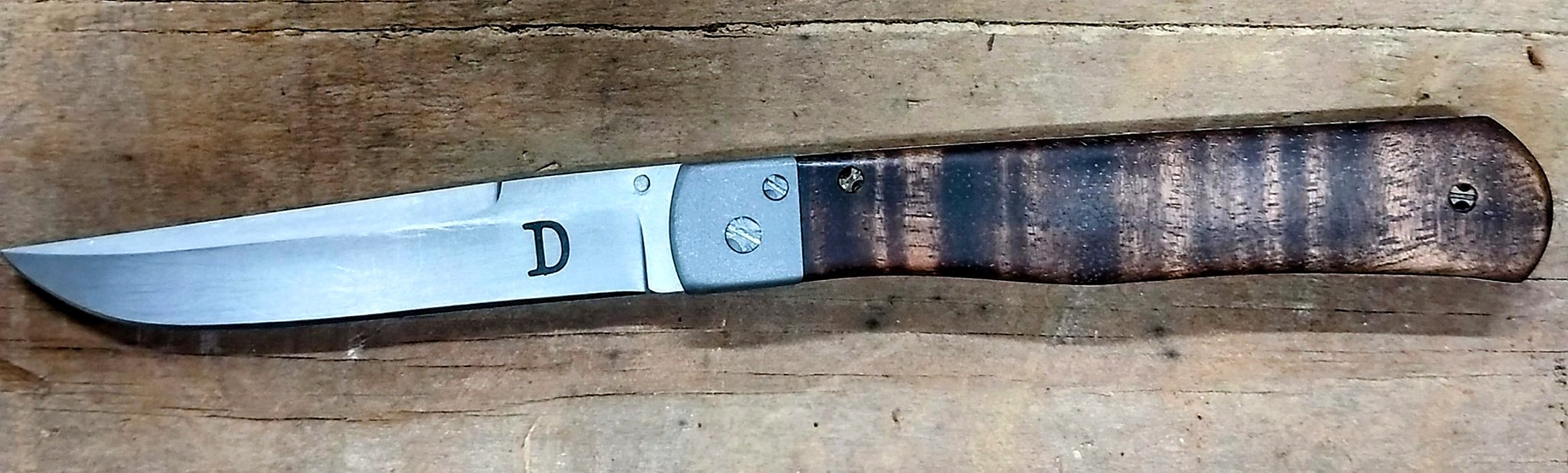 B.A. Dodson Koa wood liner lock folder with satin-finished blade, metal bolster, and figured Koa handle scales.