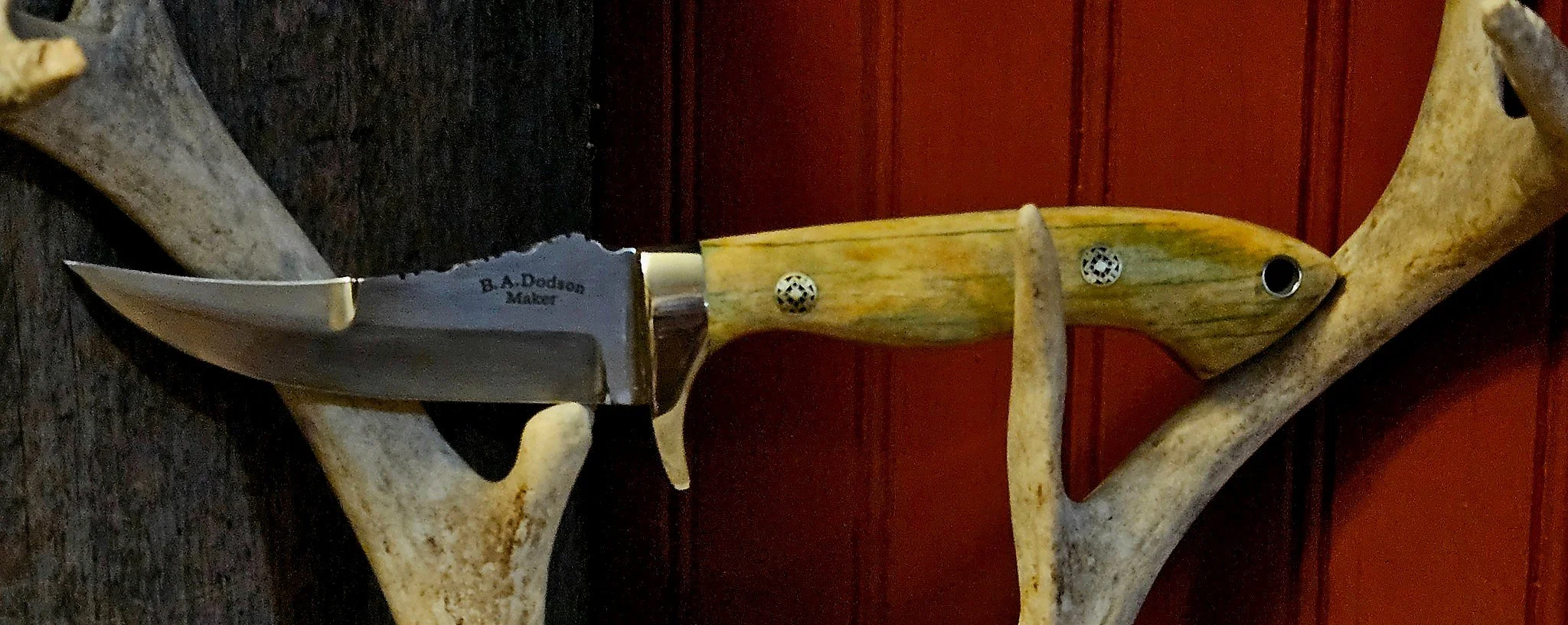 B.A. Dodson giraffe-bone fixed-blade skinner side profile showing the maker’s mark, blade grind, guard, handle pins, and lanyard tube.