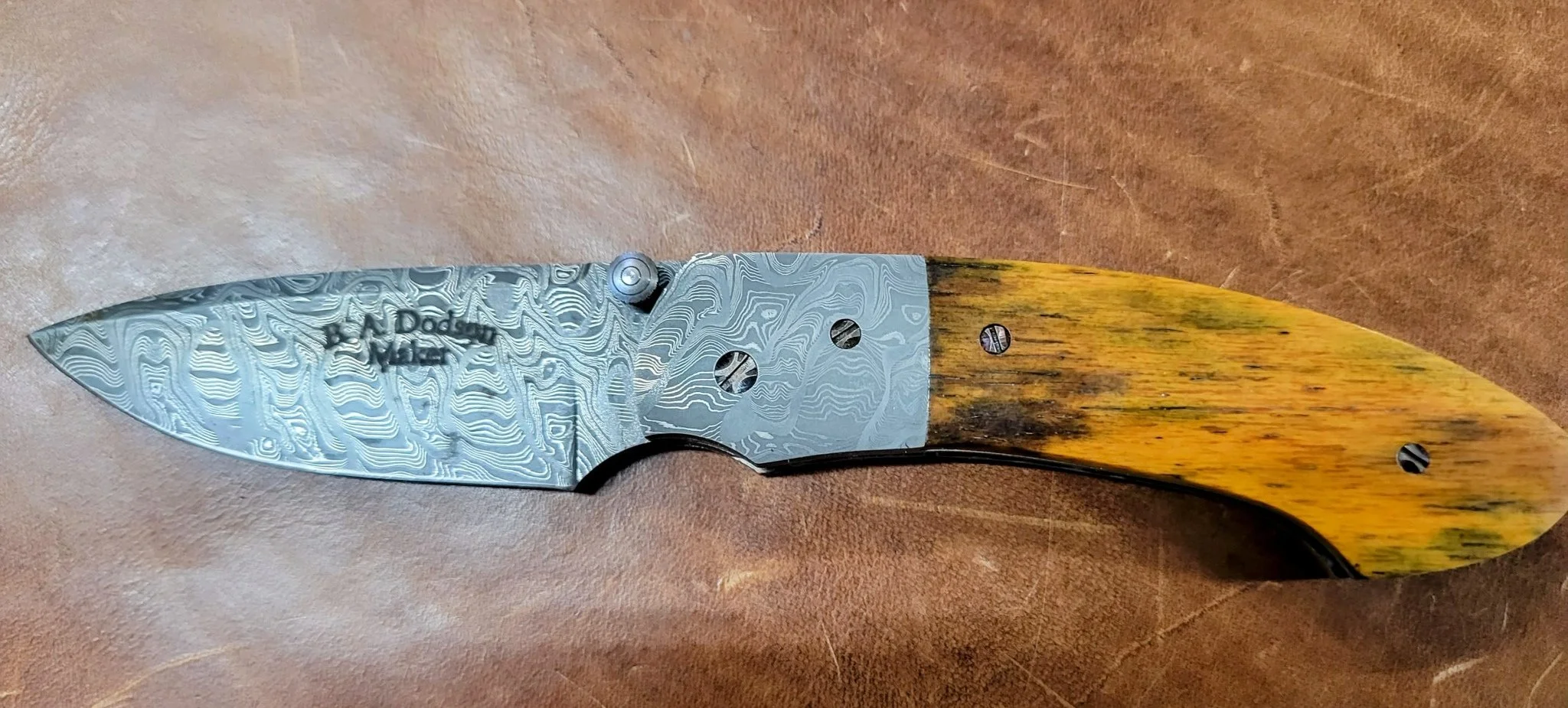 B.A. Dodson Giraffe Bone Damasteel liner lock folder showing the Damasteel Damascus blade and bolster with giraffe-bone handle scales.