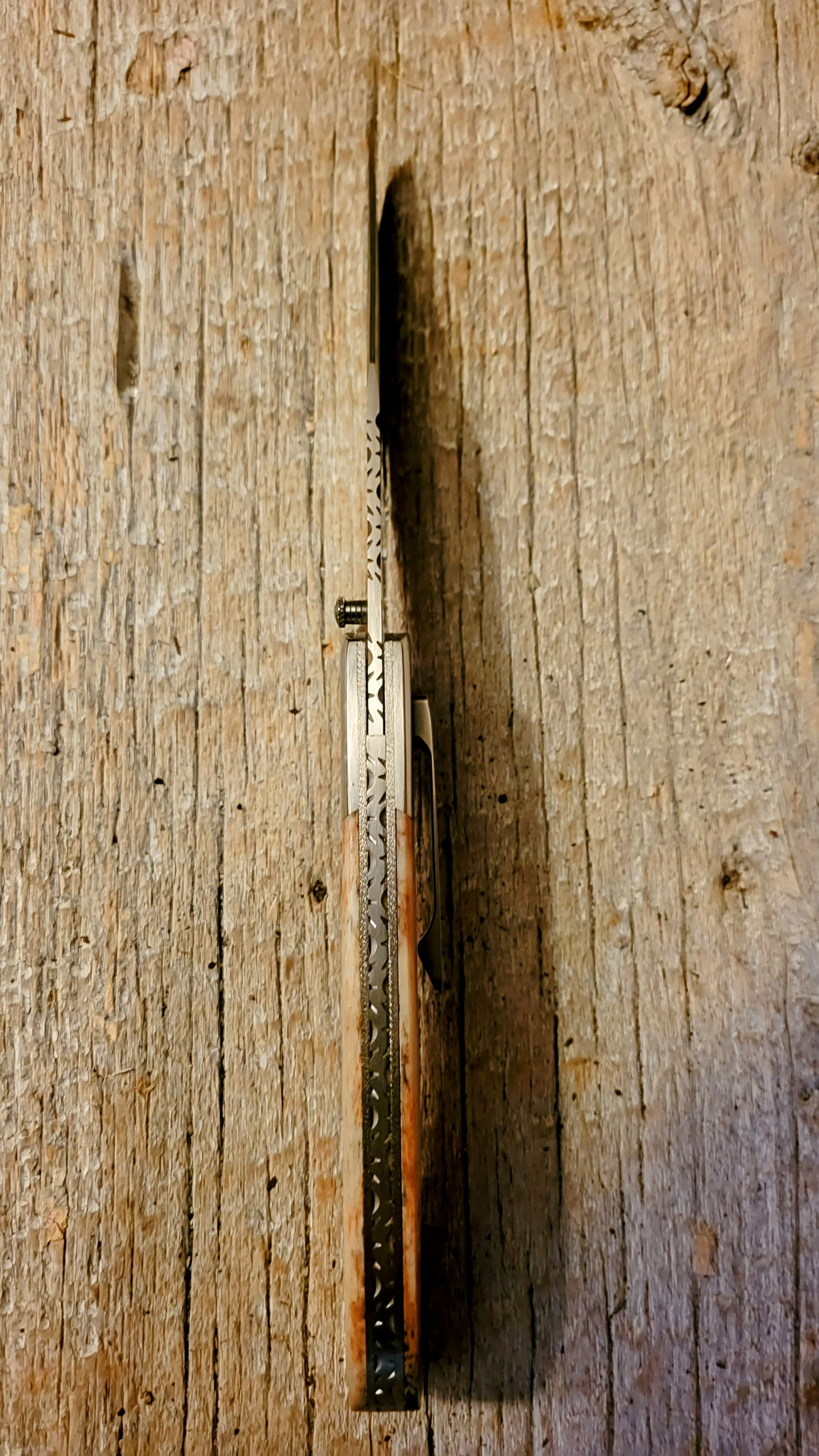 Decorative spine and backspacer file-work on a B.A. Dodson Giraffe Bone liner lock folder.