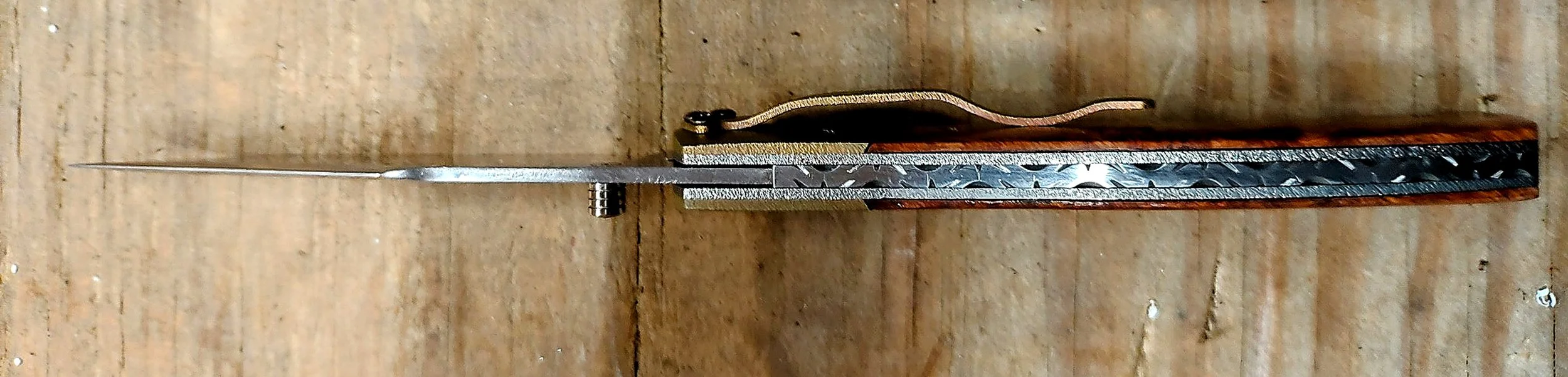 Spine, decorative backspacer file-work, and pocket clip detail on a B.A. Dodson Burl & Titanium liner lock folder.