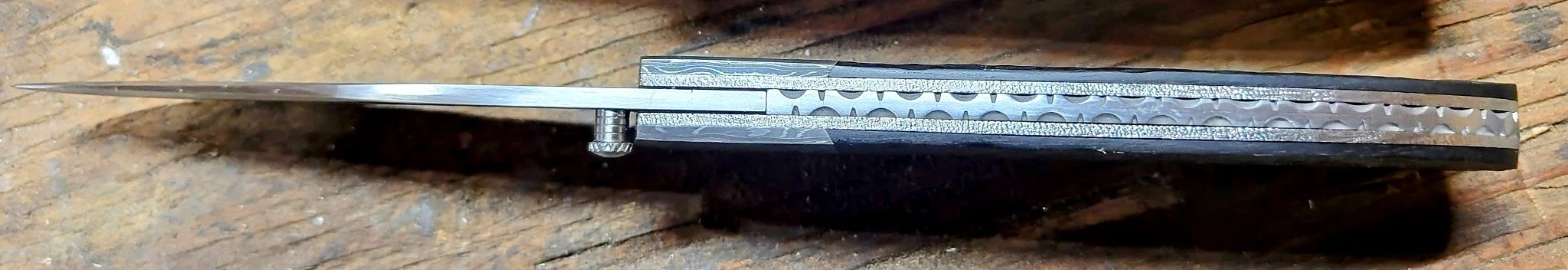 B.A. Dodson jigged African ebony liner-lock folder spine detail showing blade centering, liners, backspacer, and decorative filework