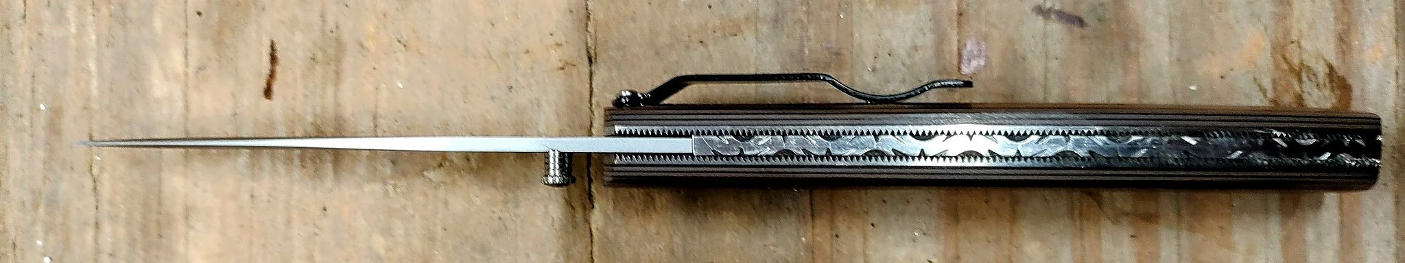 B.A. Dodson bead-blasted G-10 liner lock folder viewed from the spine, showing decorative backspacer file-work, liners, and pocket clip