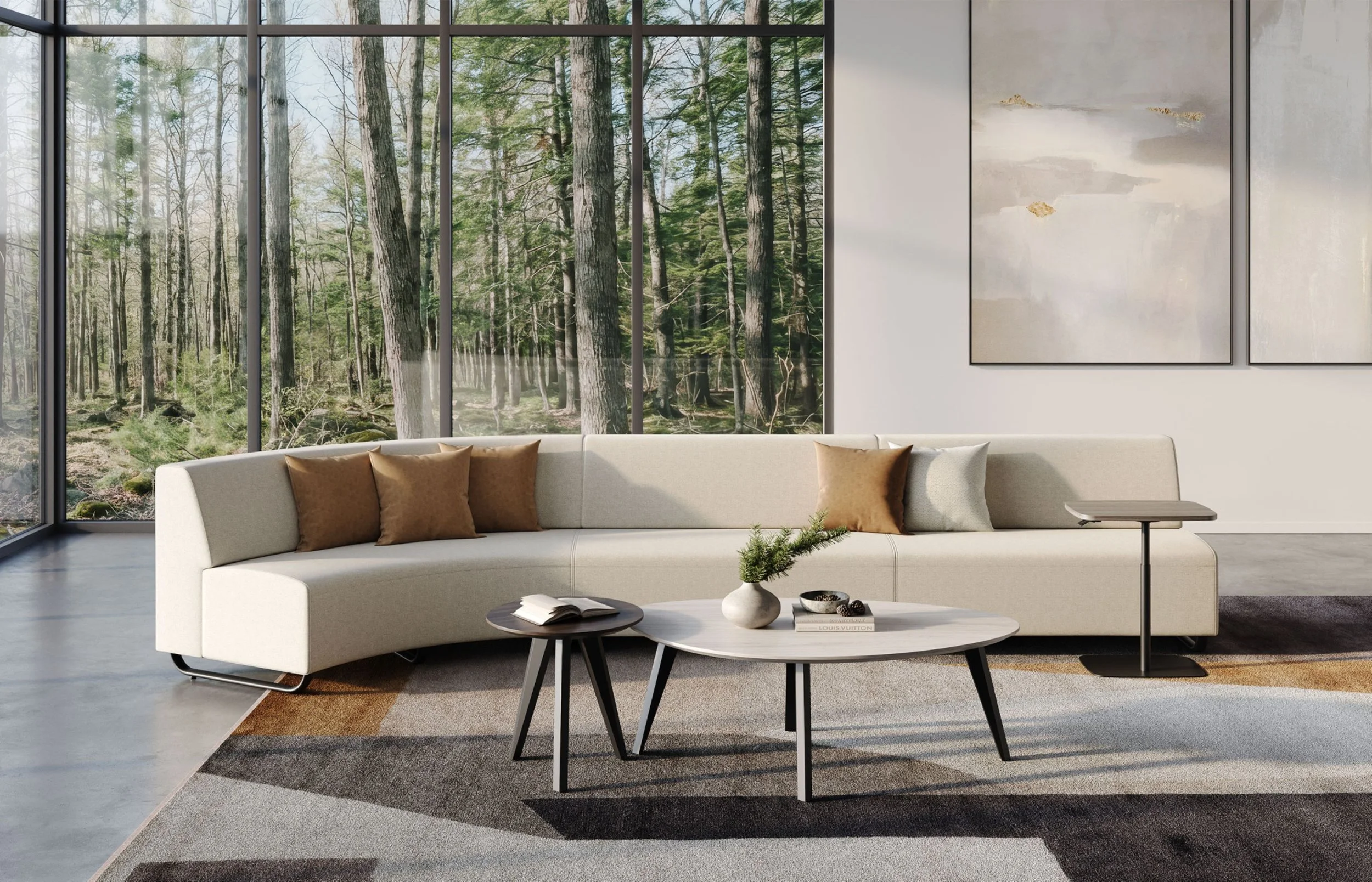 Modern living room with white sectional sofa with brown and beige pillows, round coffee tables with decorative items, large floor-to-ceiling windows showing a wooded outdoor scene, and abstract wall art.