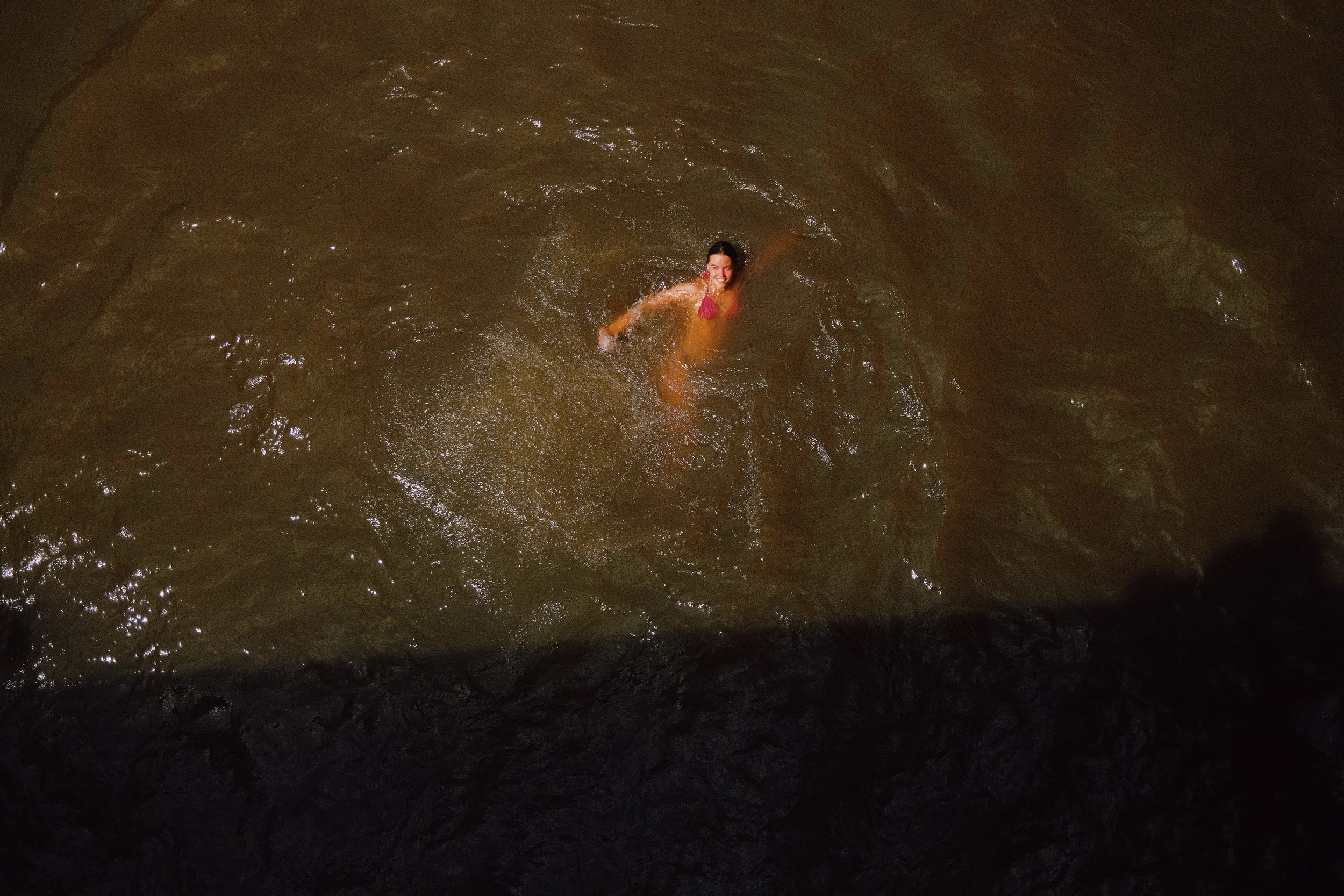 Une personne nageant dans une rivière ou un fleuve, probablement dans un environnement naturel.