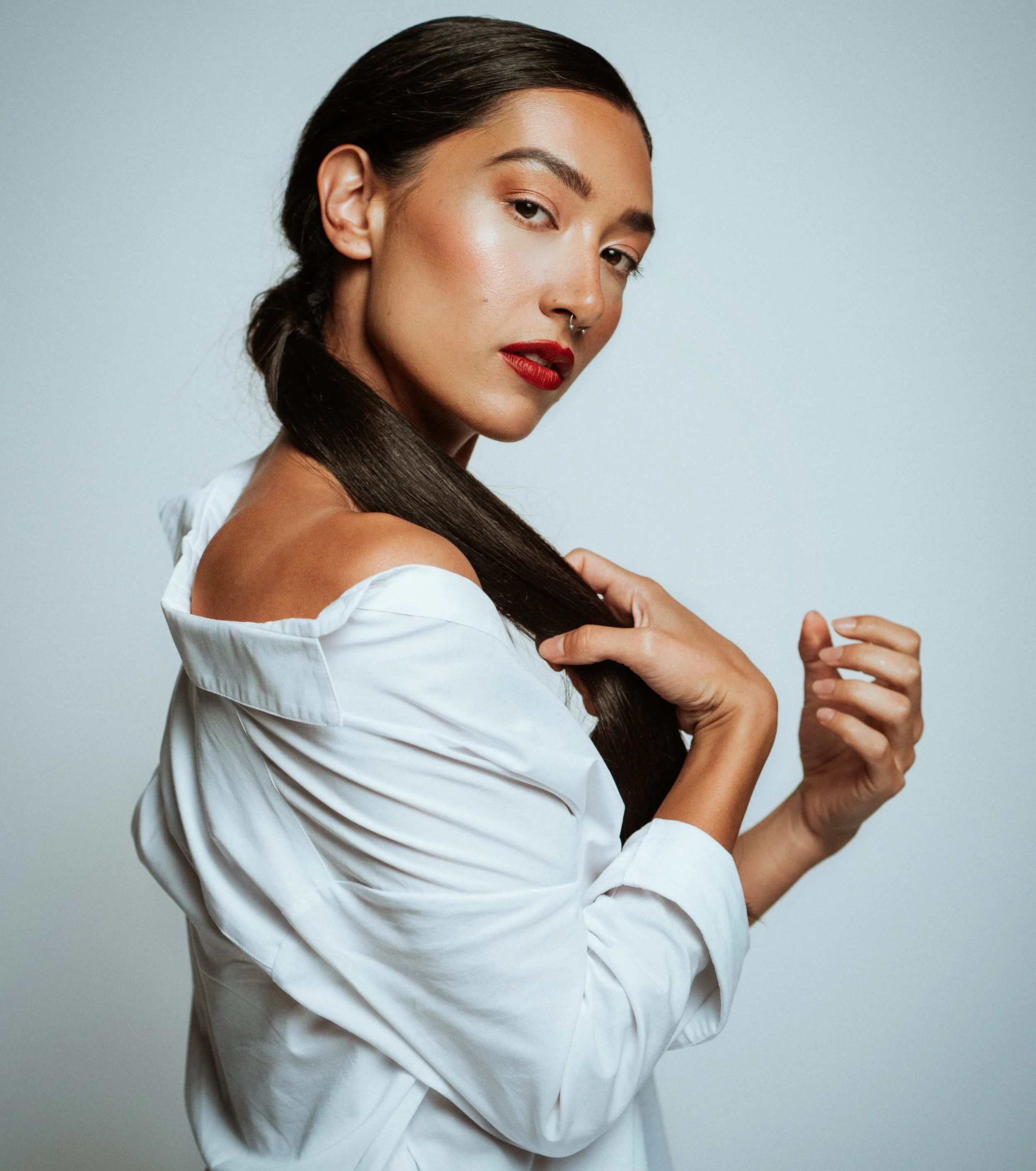 Bold red lip and clean complexion showcasing classic beauty. Detail oriented makeup applied with precision by Kinga, ideal for lipstick and cosmetic campaigns.