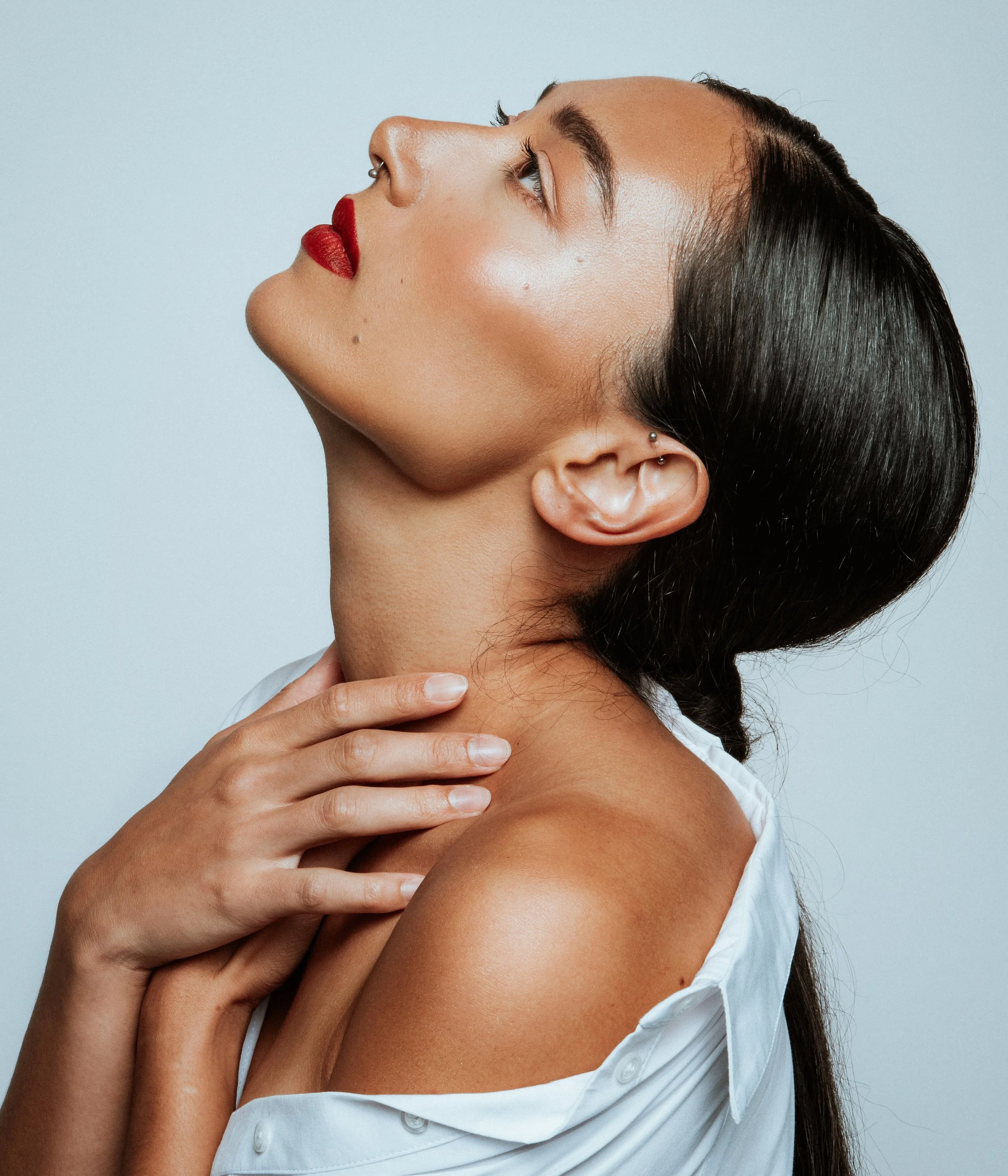 Bold red lip and clean complexion showcasing classic beauty. Detail oriented makeup applied with precision by Kinga, ideal for lipstick and cosmetic campaigns.