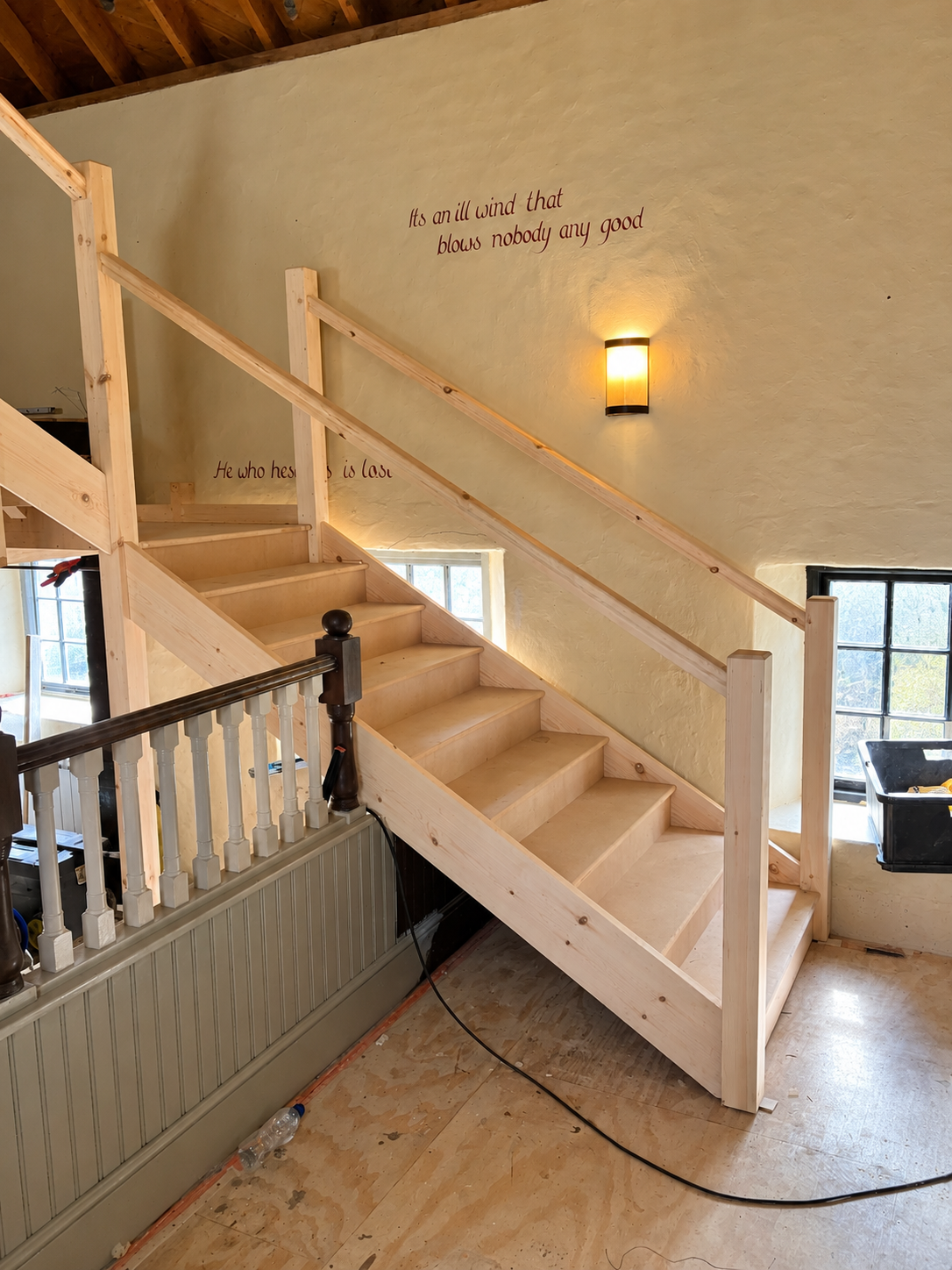 Unfinished Staircase Renovation with Warm Sconce.png