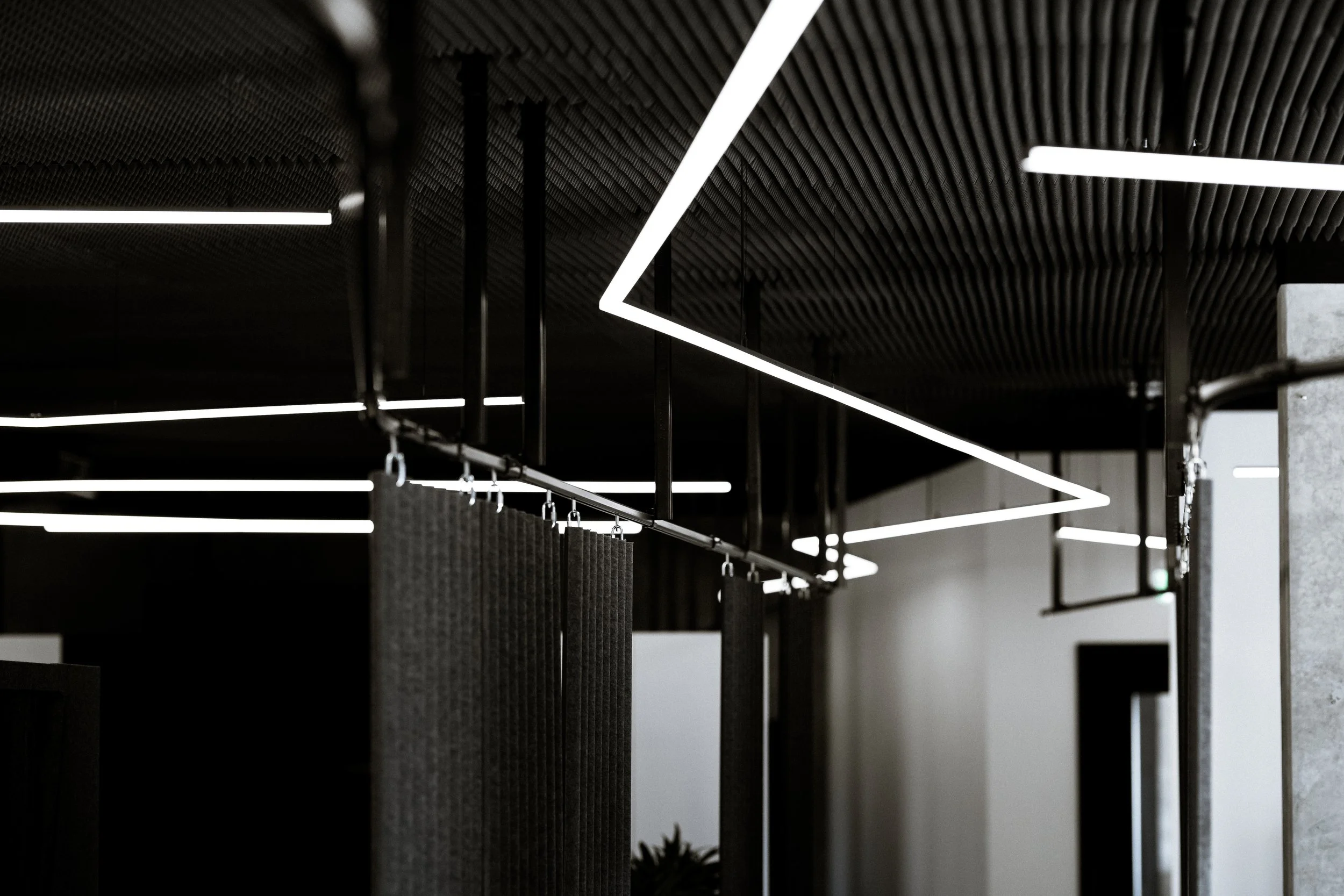 Moderne Innenarchitektur mit schwarzen und weißen geometrischen Lichtelementen an der Decke.