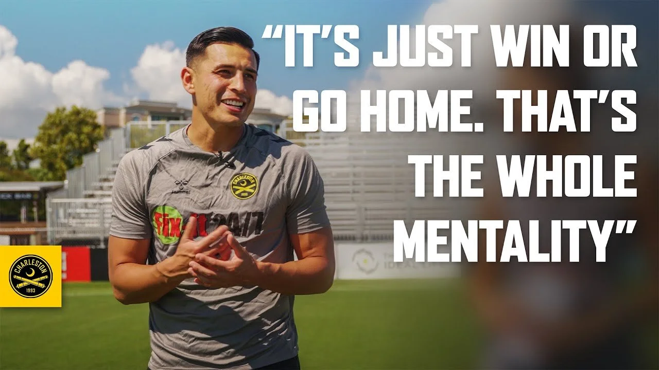 A smiling man in sports attire standing on a football field with a quote overlay that reads, "It's just win or go home. That's the whole mentality."