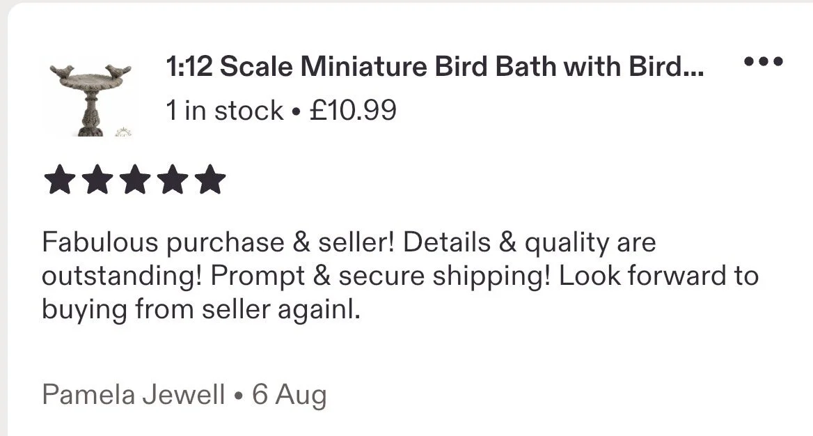 Online product listing for a 1:12 scale miniature bird bath with a bird on top, priced at £10.99, with a five-star rating and positive customer review.