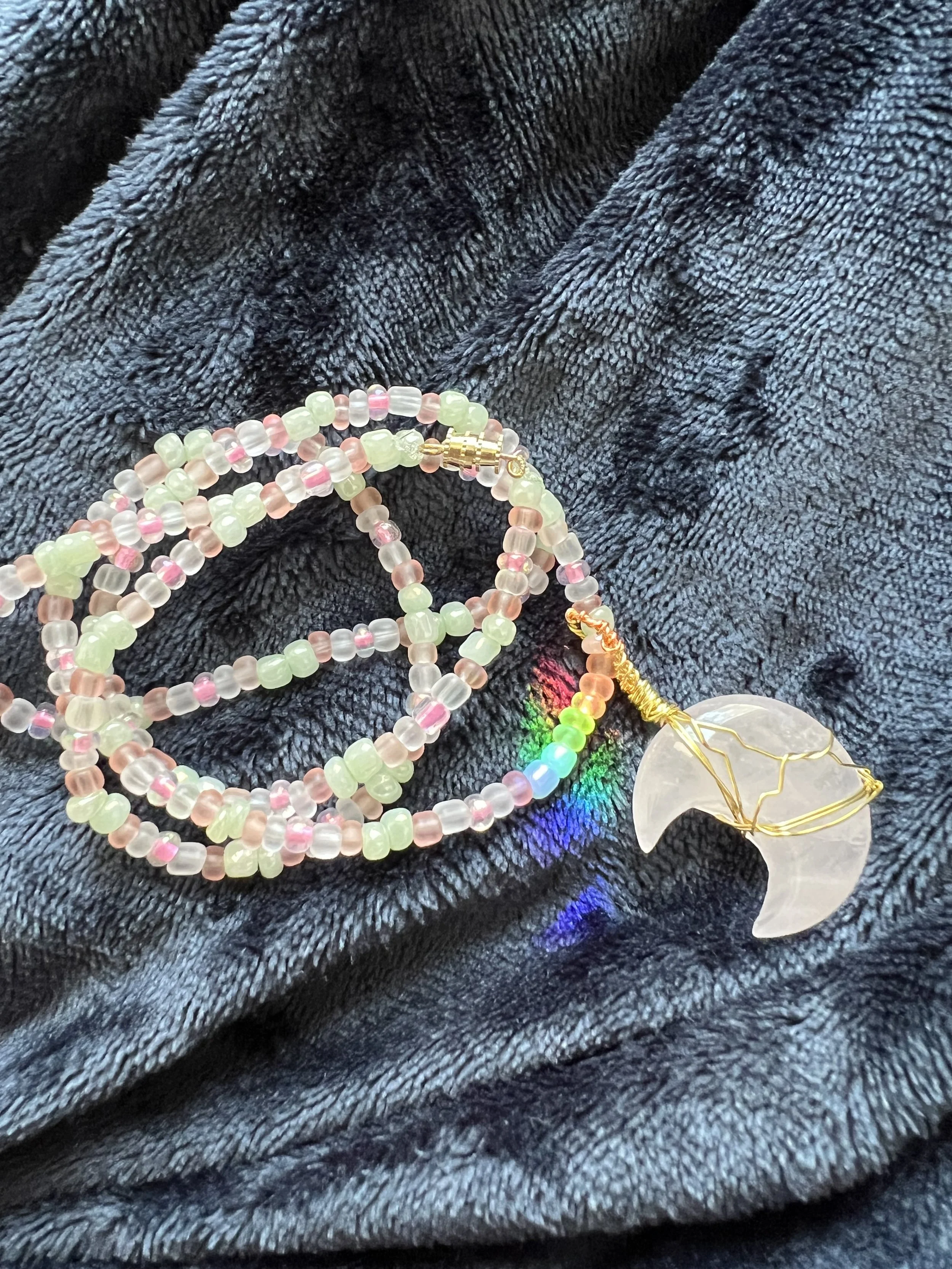 Colorful beaded jewelry or accessories on a dark, textured fabric background