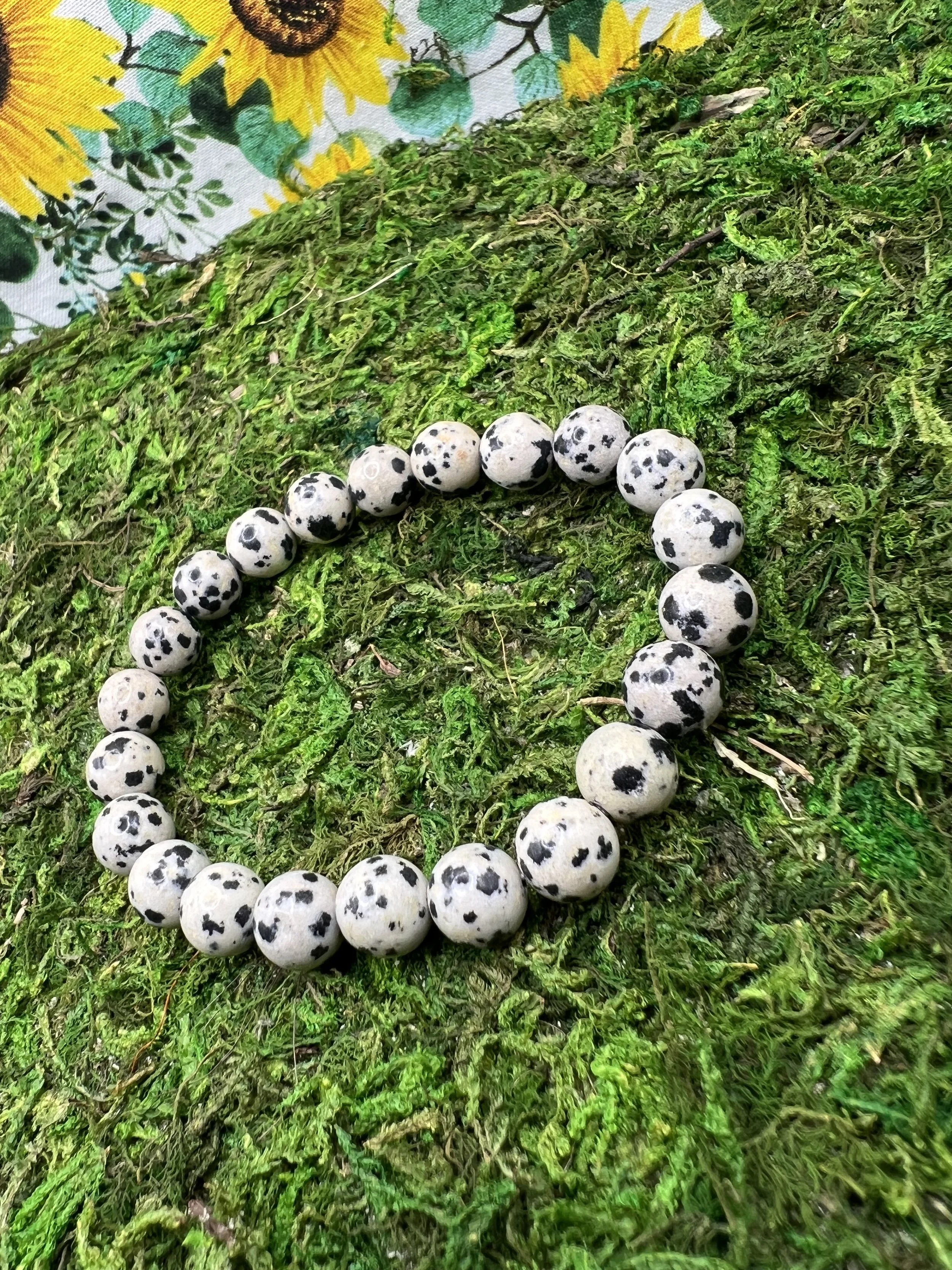Cluster of speckled quail eggs resting on green moss, with a sunflower-themed cloth in the background.