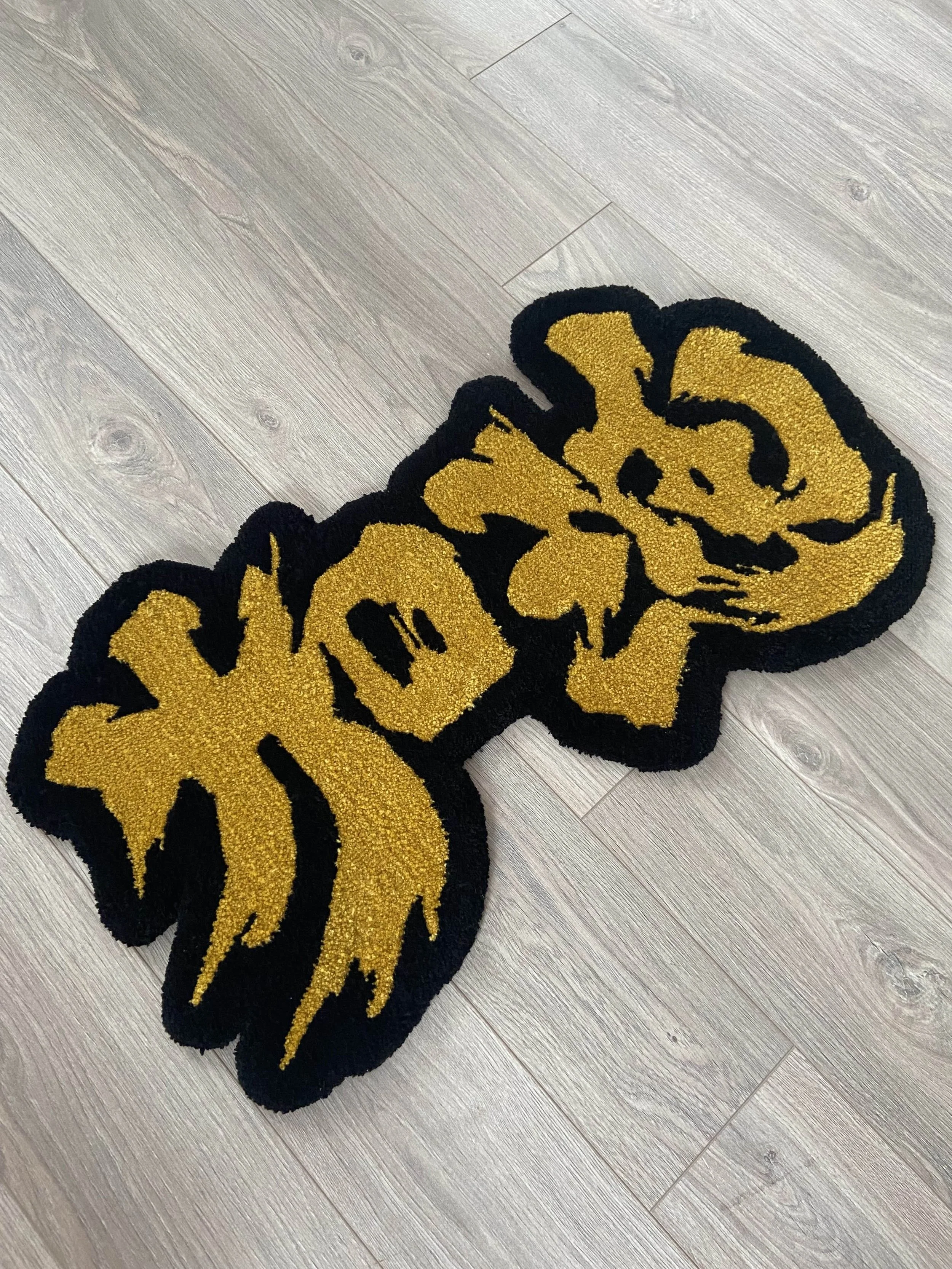Close-up of a Chinese calligraphy rug on a wooden floor.