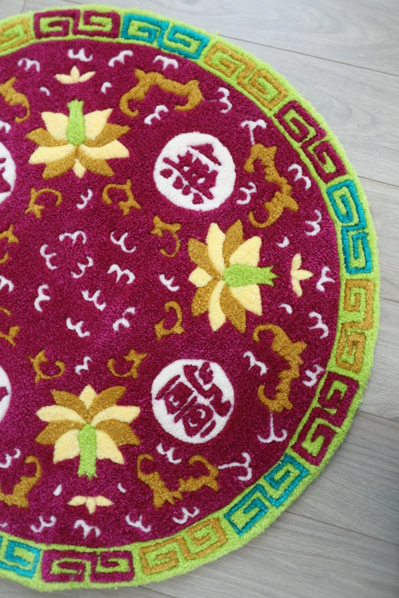 Close-up image of a  rug with Boundless Longevity patterns on a light wooden floor.