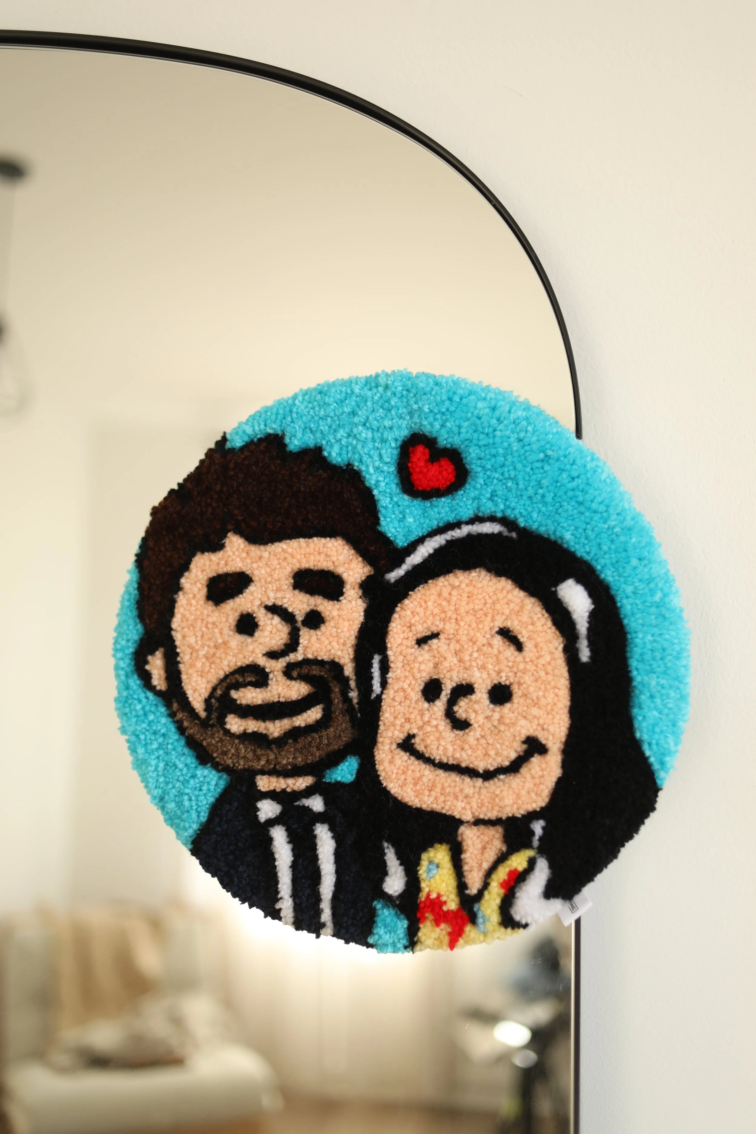 Colourful circular art piece featuring cartoon characters of a boy and girl with happy expressions, a red heart, and bright background.