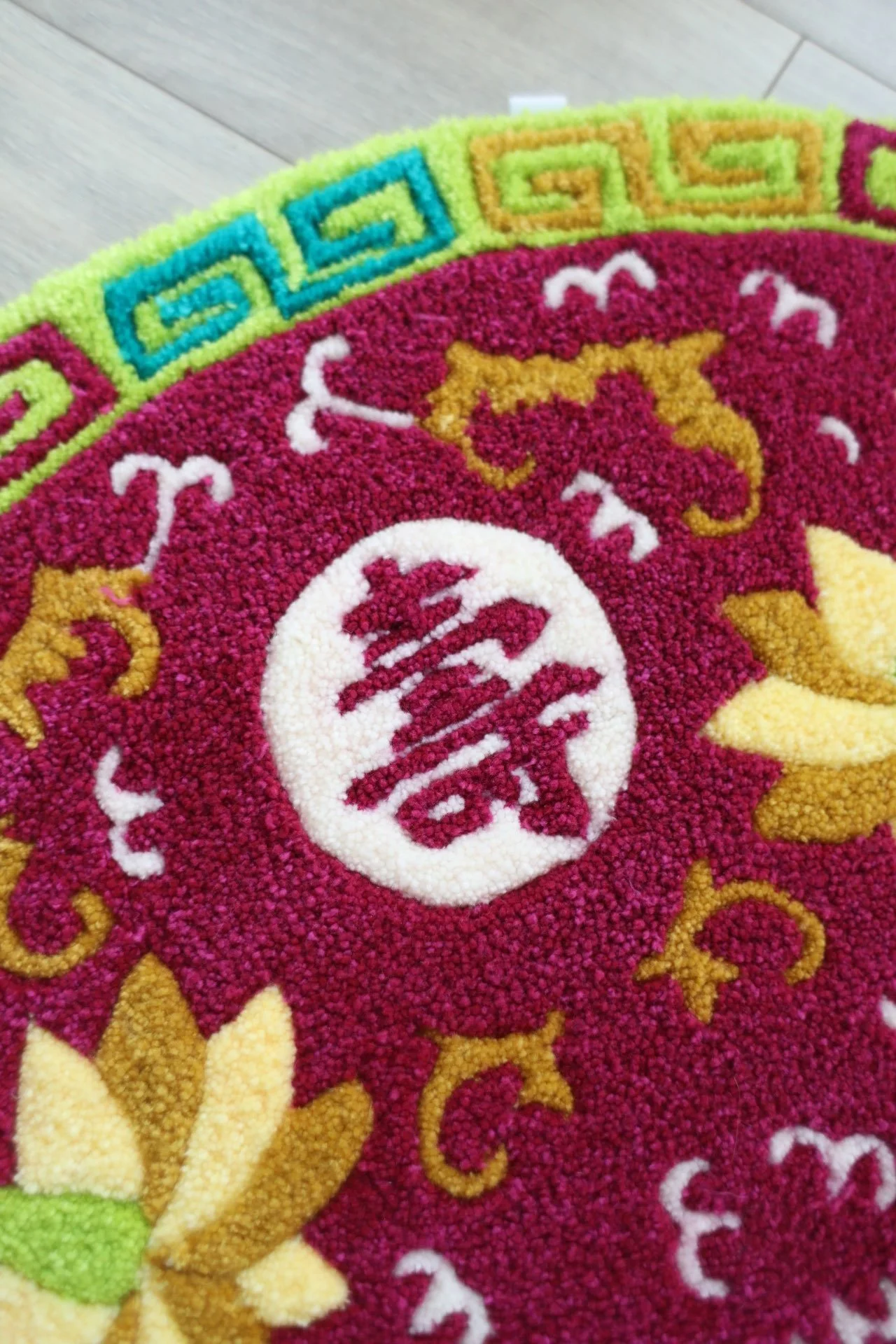 Close-up image of a  rug with Boundless Longevity patterns on a light wooden floor.