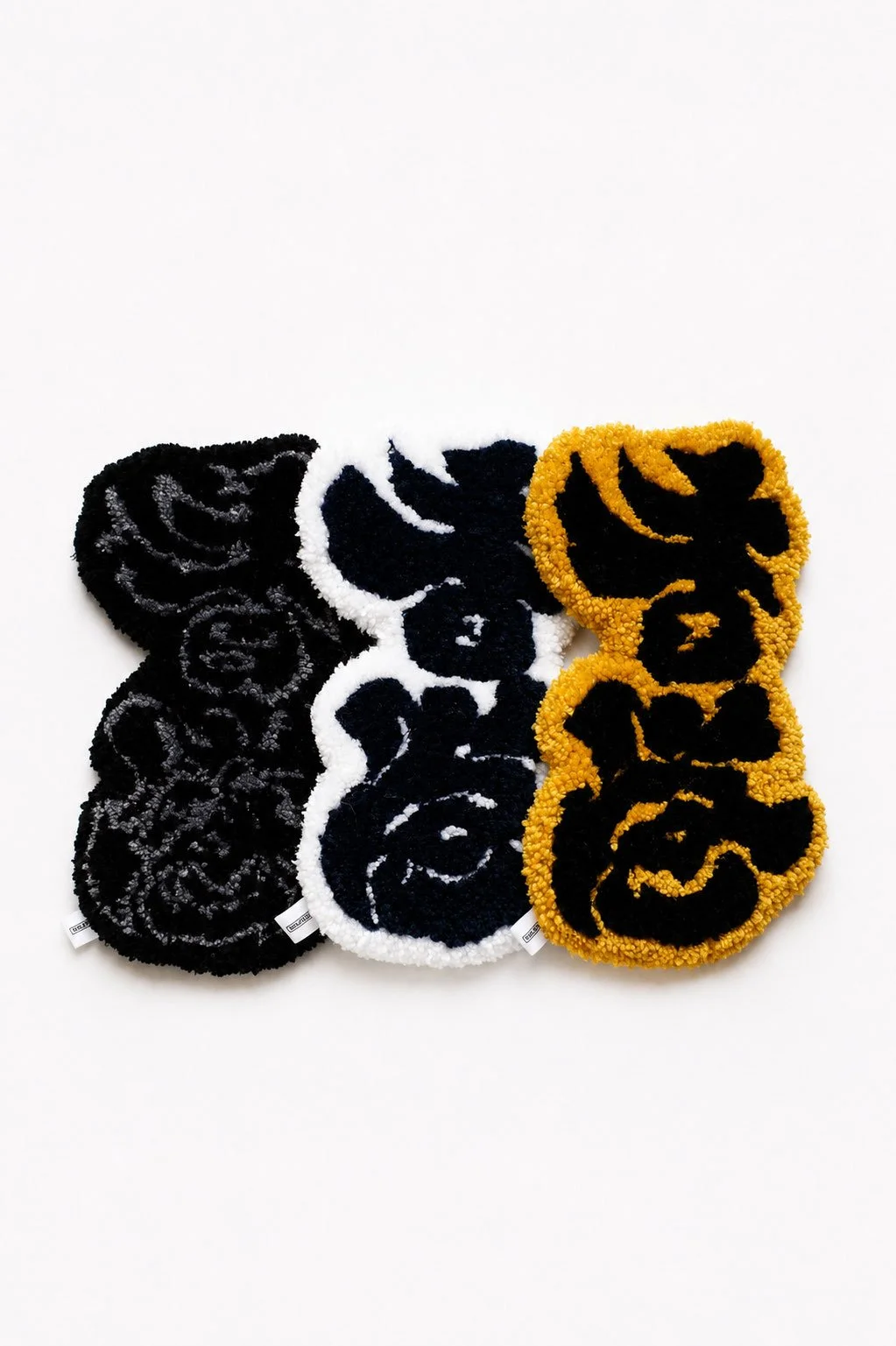 Floor rugs with Chinese calligraphy in black, white, and gold colors arranged on a white background.