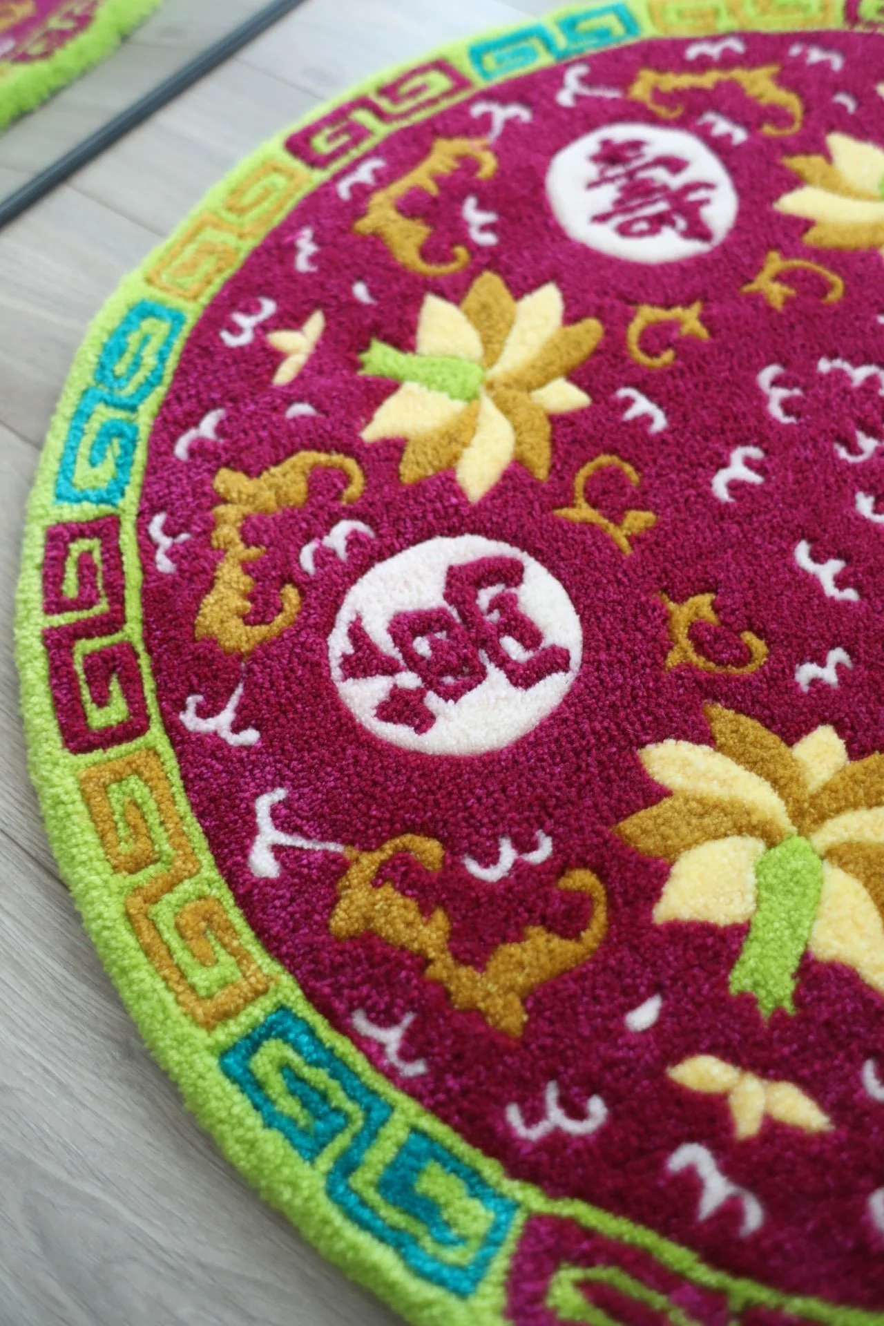 Close-up image of a  rug with Boundless Longevity patterns on a light wooden floor.