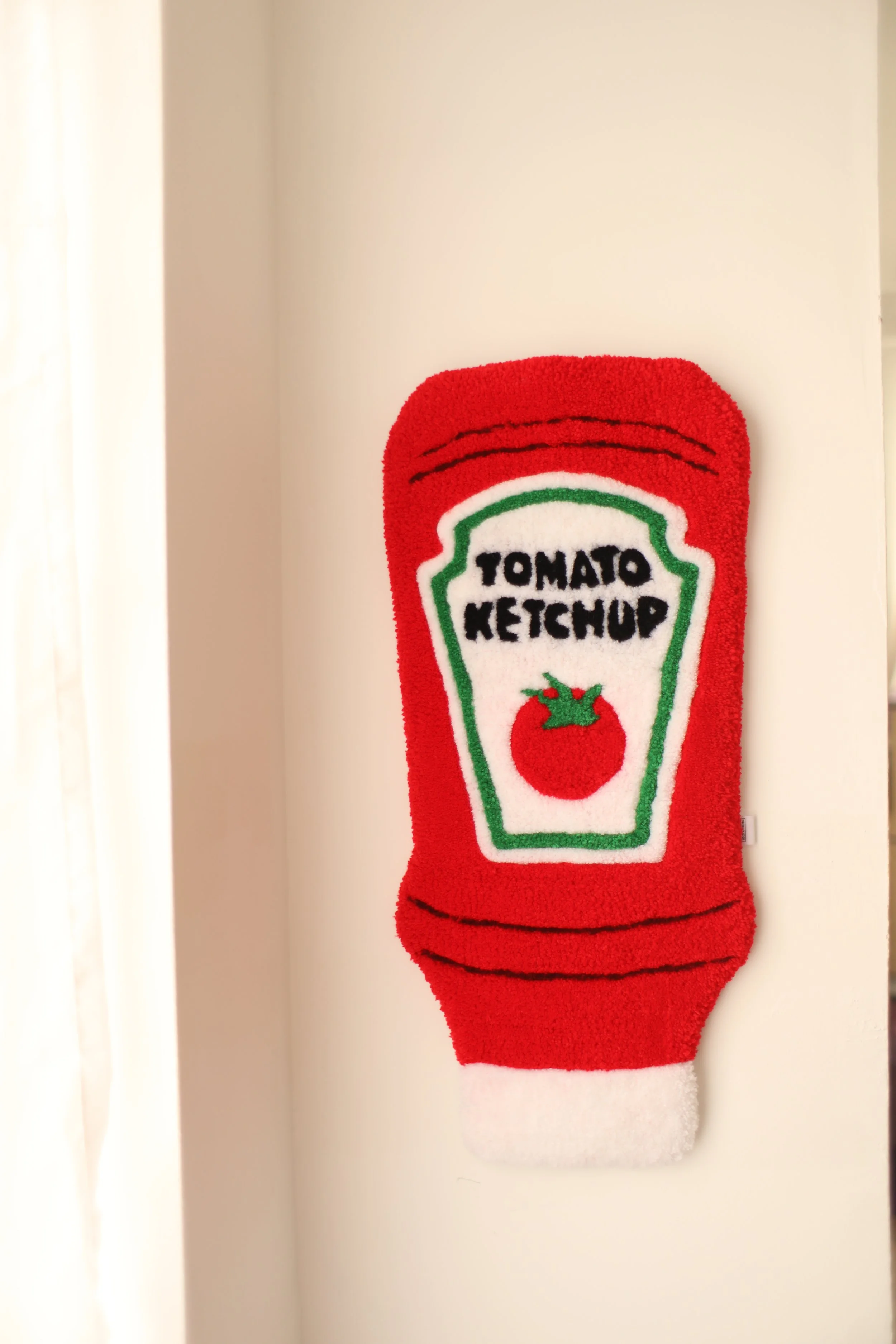 Red Christmas stocking with a design resembling a ketchup bottle, featuring the words "TOMATO KETCHUP" and an illustration of a tomato.
