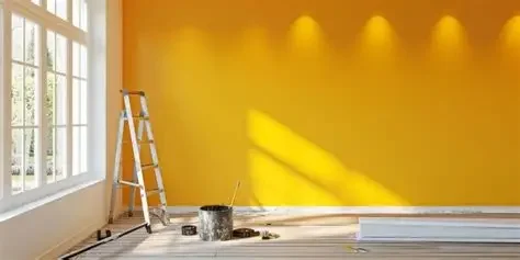 A room with a yellow wall, large windows, a ladder, and painting supplies on the floor.