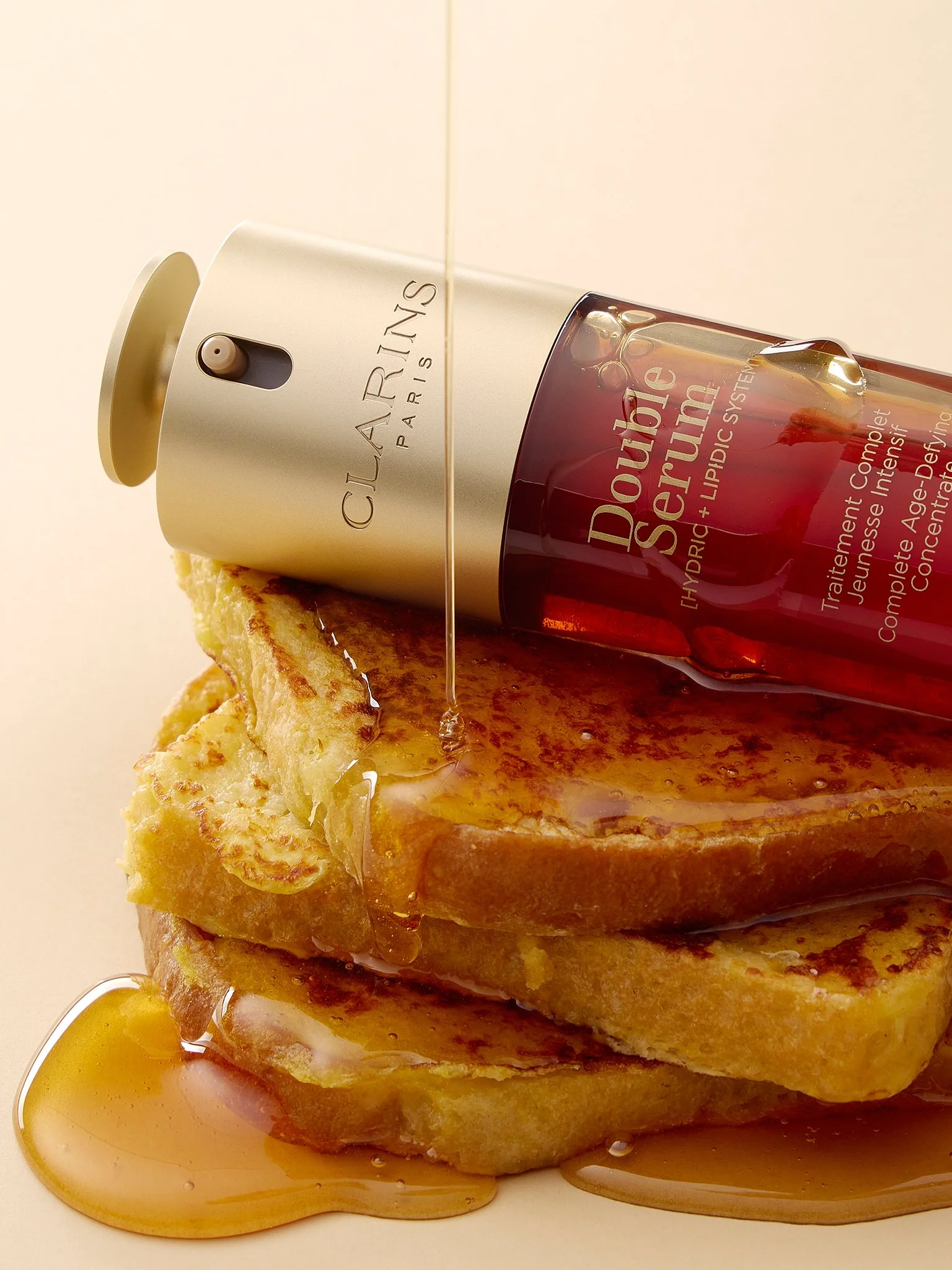 Three slices of French toast topped with maple syrup, with a bottle of Clarin's dual-action lip treatment and a small container of syrup on top.