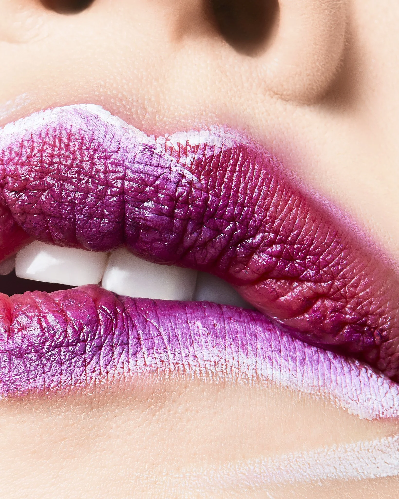 Close-up of lips painted with pink lipstick, showing detailed texture and cracking of the lipstick on the upper and lower lips.