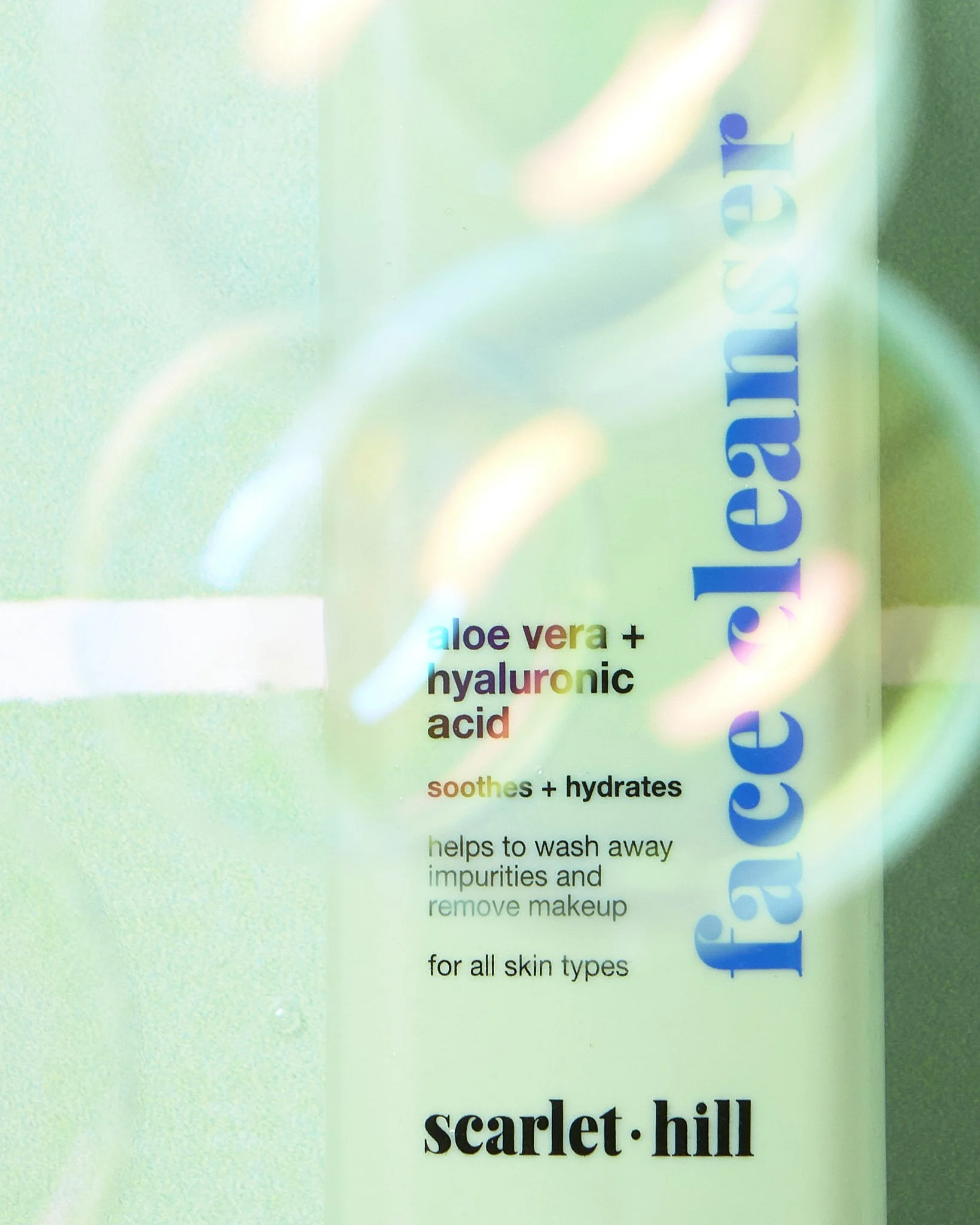A skincare product label with text about aloe vera and hyaluronic acid, mentioning benefits like soothing, hydrating, cleansing, and removal of makeup, on a pastel-colored background.
