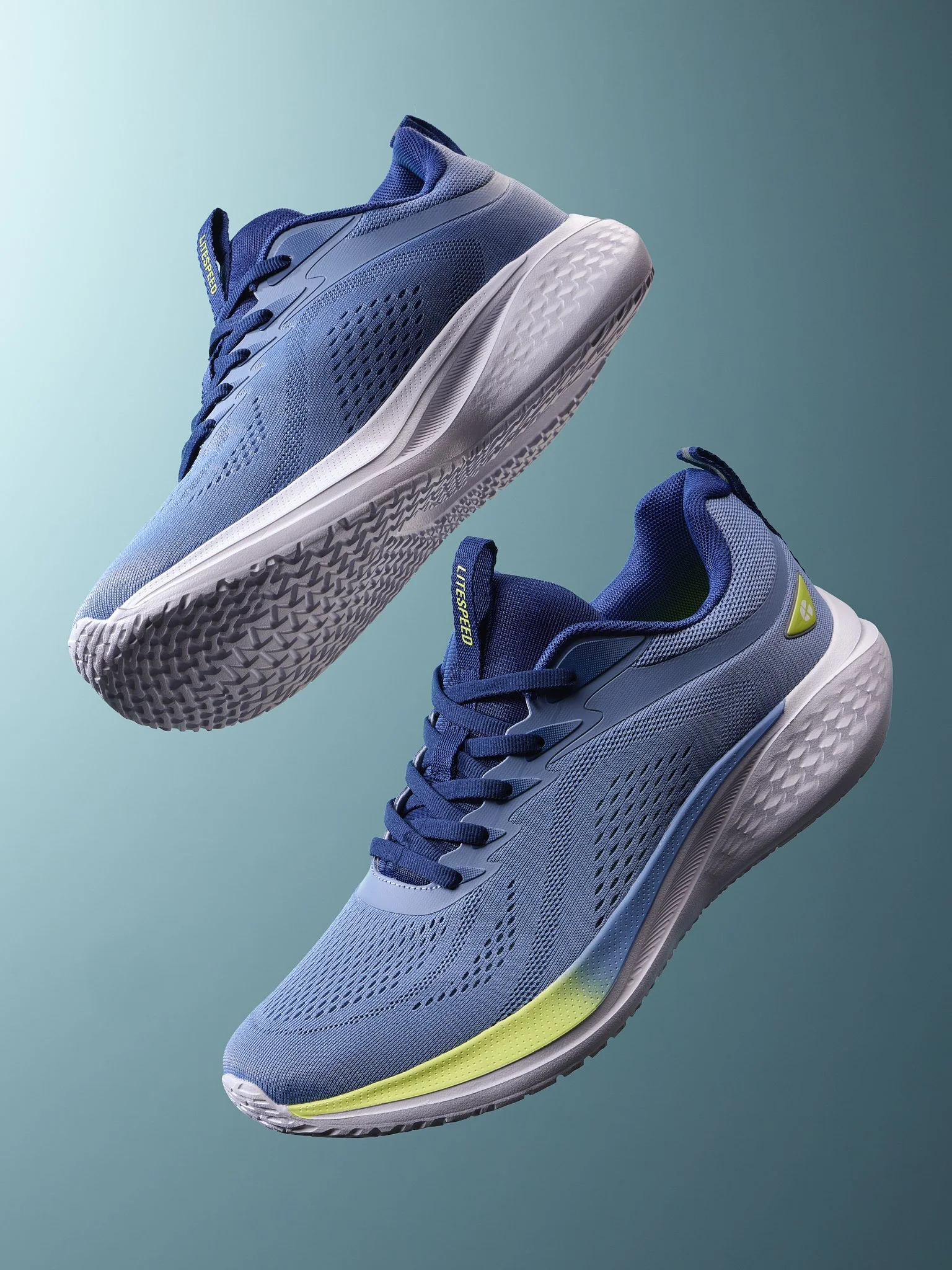 A pair of modern running shoes hover against a gradient blue-green background, featuring a sleek design with mesh fabric, a white sole, and accents of yellow and navy blue.