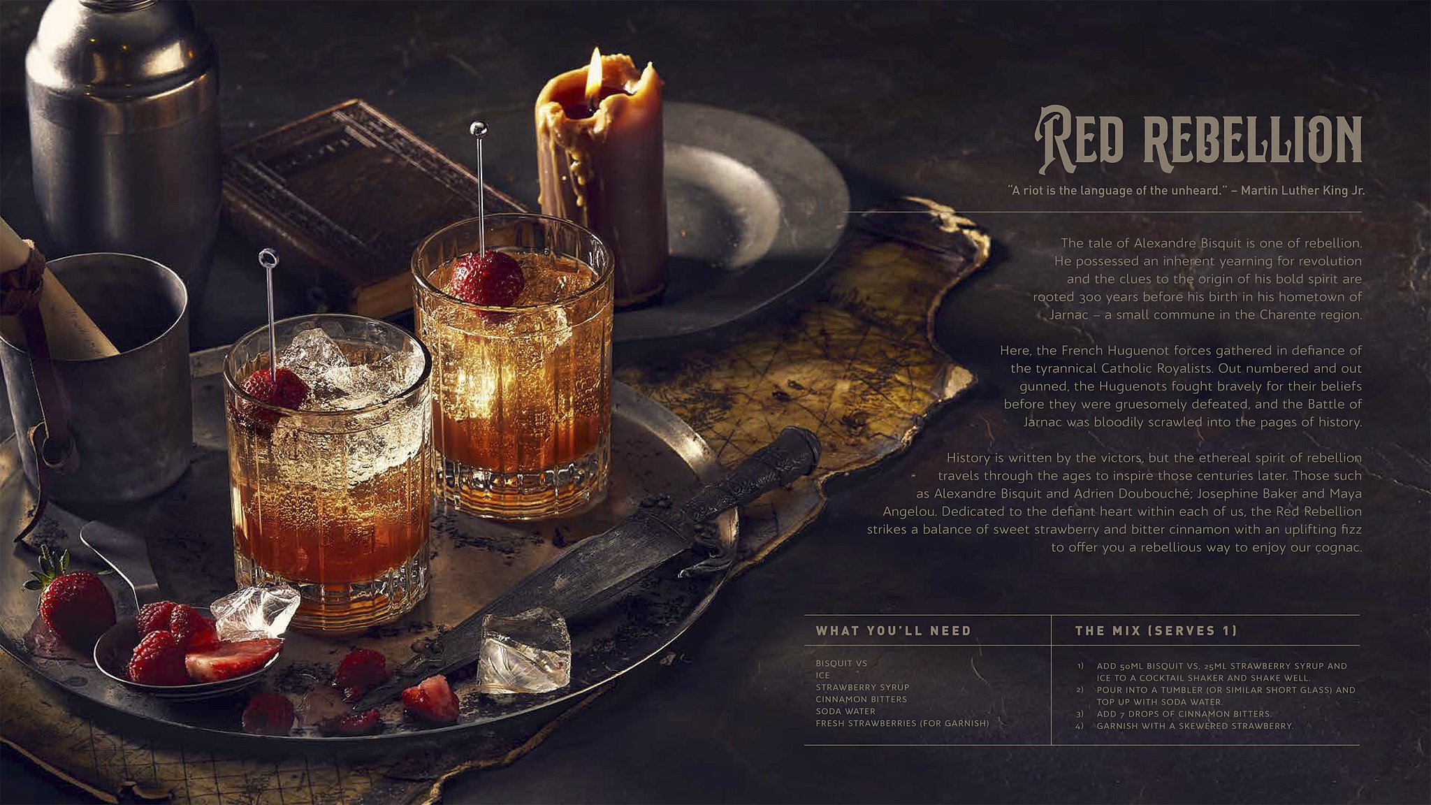 A rustic wooden table with two glasses of cocktail garnished with cherries and strawberries, ice, a candle, a vintage book, and a knife. The table is dark and atmospheric.