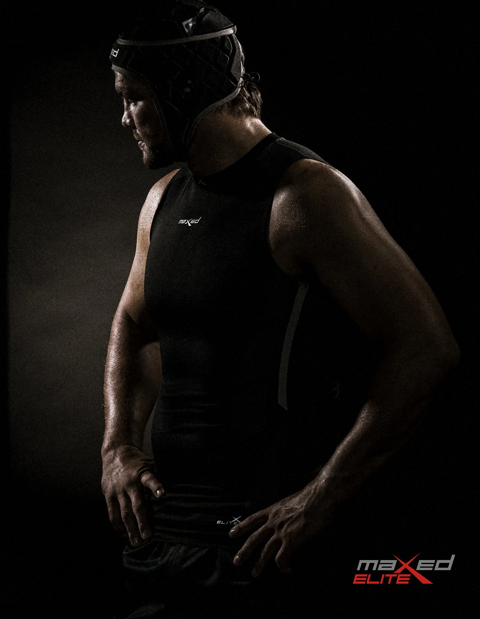 A muscular man wearing a black athletic tank top and a black cap with sweat on his skin, standing against a dark background. The logo "maxed ELITE" is visible in the lower right corner of the image. Flip vd Merwe Springbok rugby