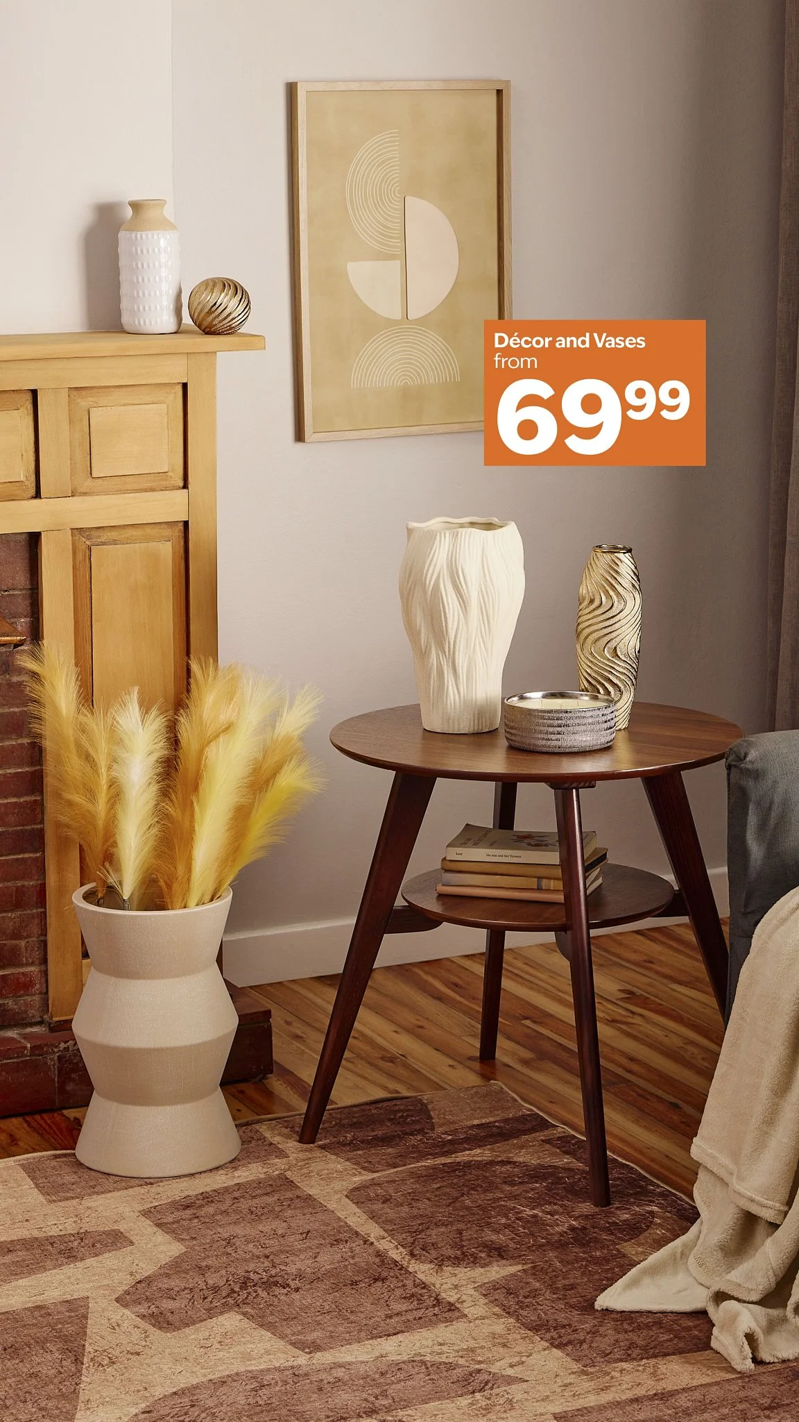 Interior living room with a wooden table holding decorative vases, a large framed abstract art piece on the wall, a potted plant with yellow pampas grass, and a rug on hardwood floor.