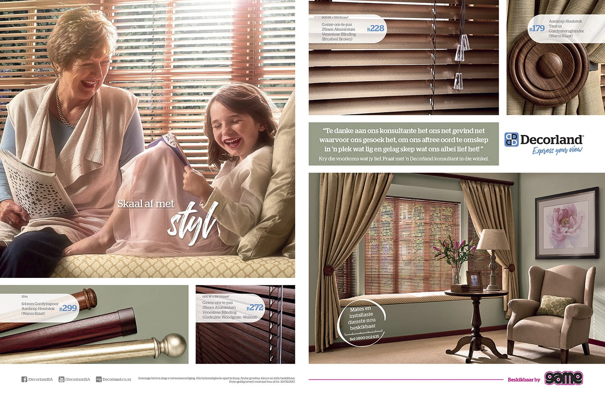 An elderly woman and a young girl sitting on a couch, smiling and looking at a book, with wooden blinds and sunlight in the background.