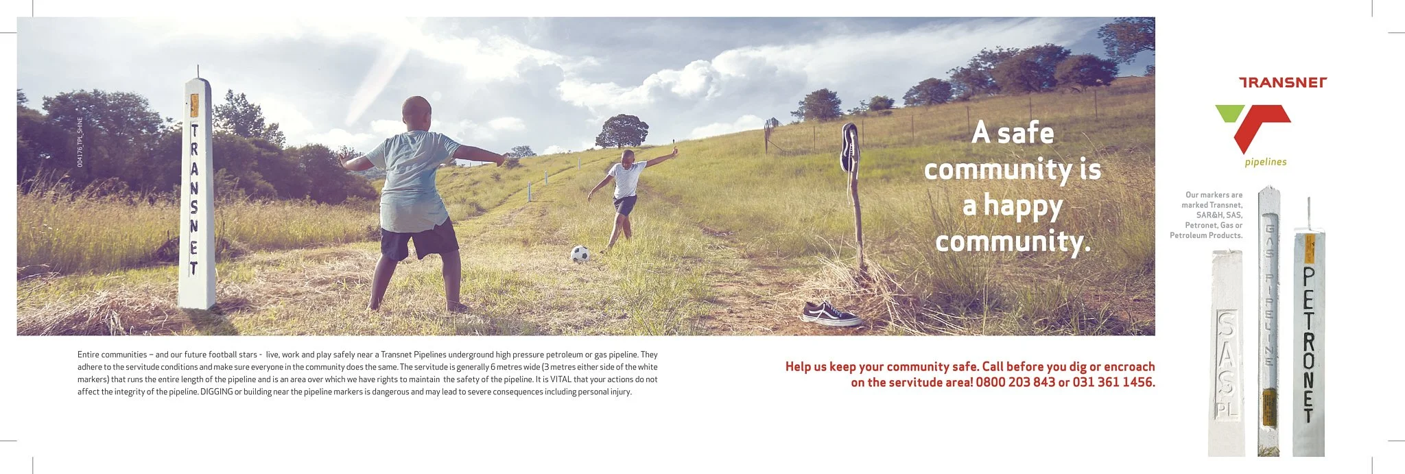 Children playing soccer on a grassy field next to a Transnet pipeline marker in an open landscape with hills and trees under a partly cloudy sky. The text reads, 'A safe community is a happy community', along with safety instructions and contact info