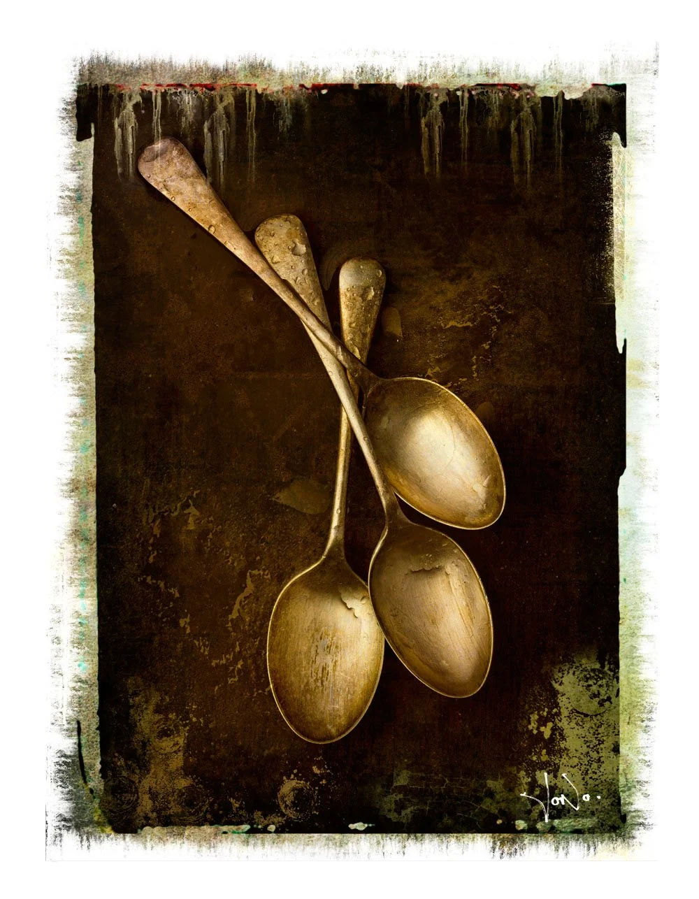 Three antique metal spoons arranged on a dark, aged surface with a polaroid transfer border.