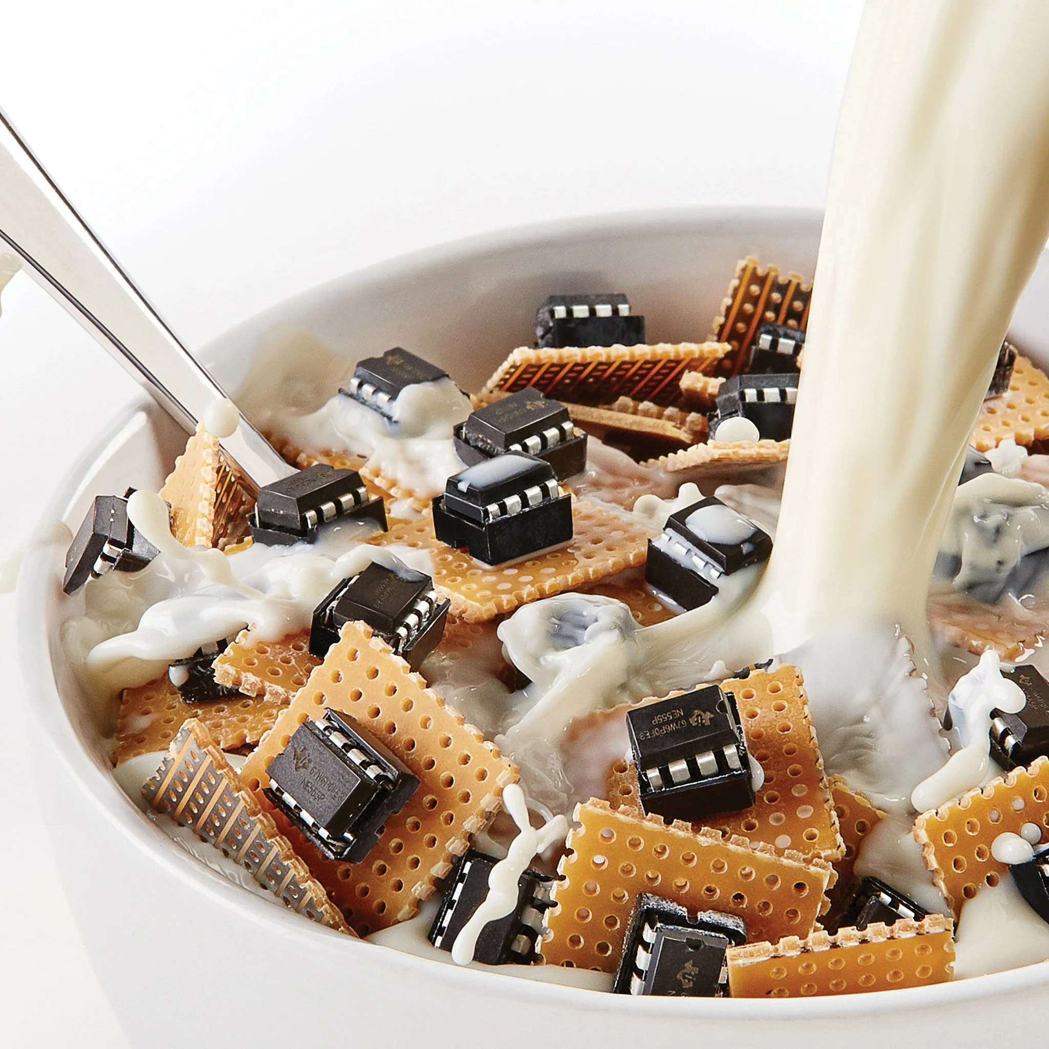 A white bowl filled with broken pieces of microchips and electronic wafers, with cream pouring over them and topped with white cream dollops. As if it is a breakfast cereal.
