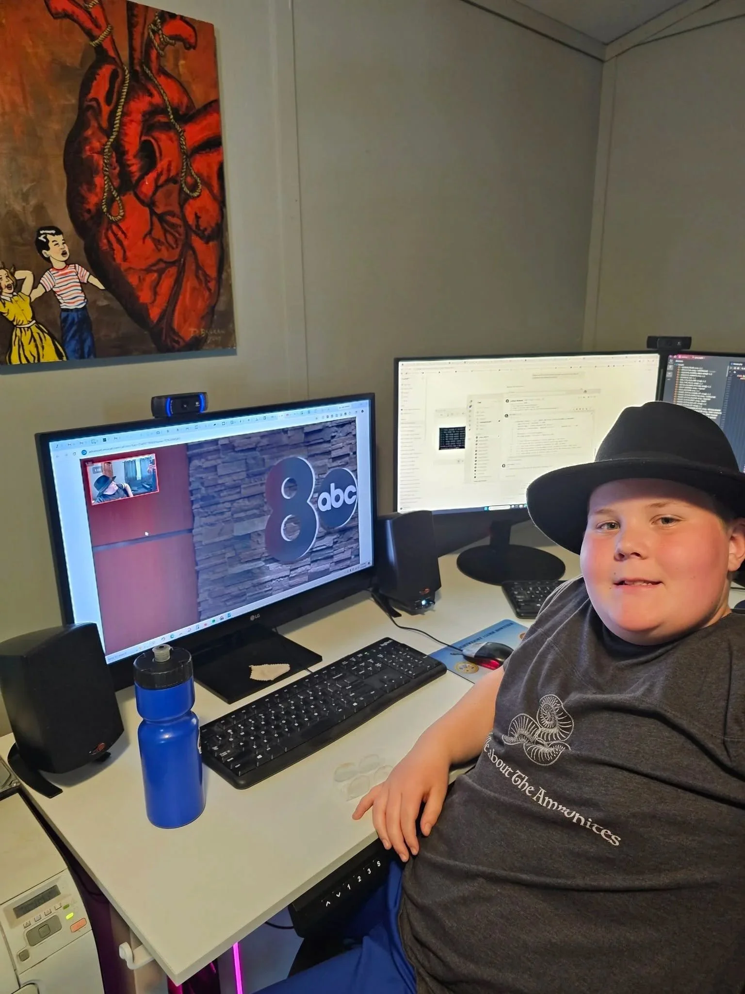 Anderson Taylor beside two computer monitors and a microphone during a museum media interview.