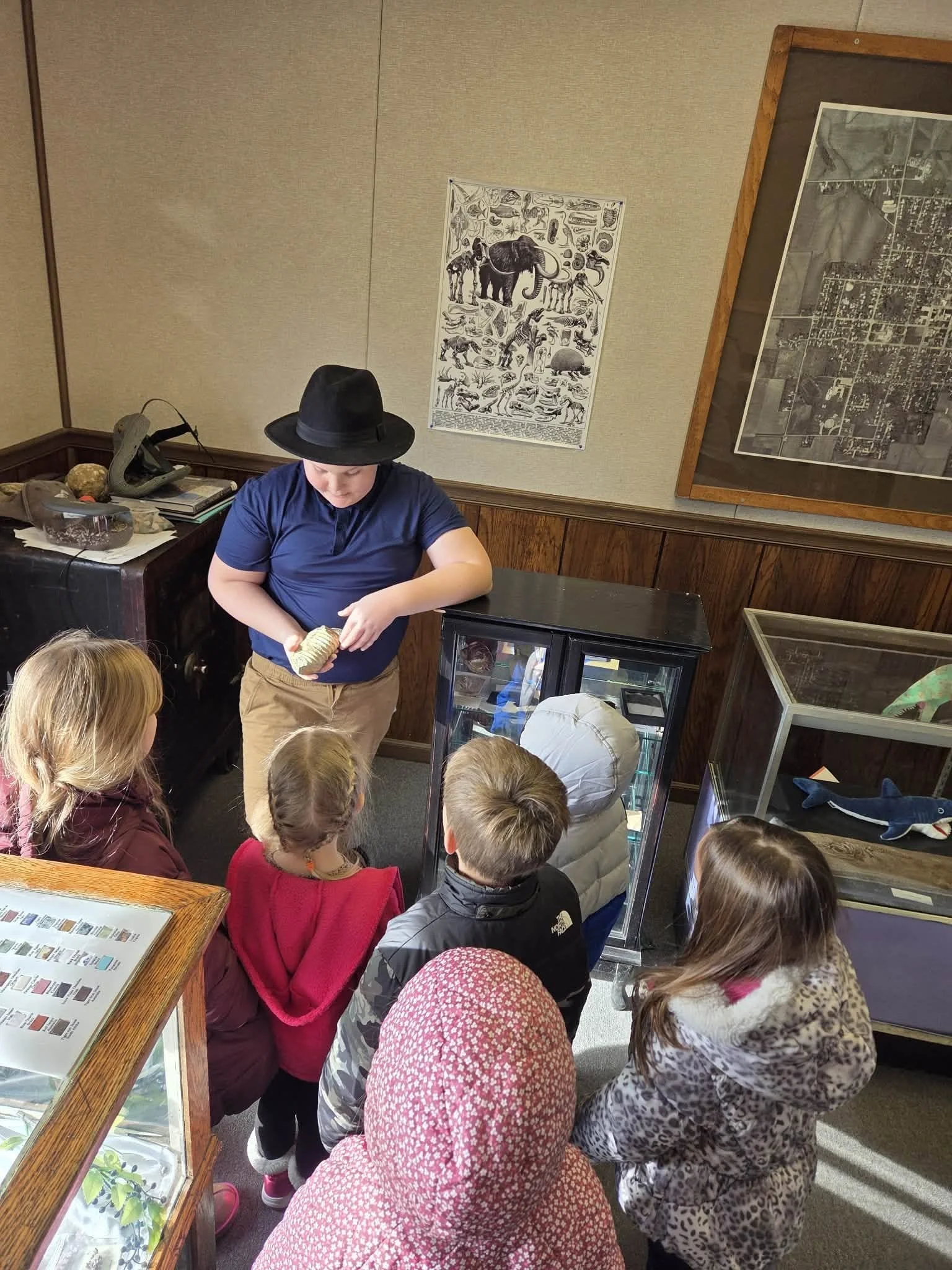 A group of young visitors and adult chaperones gathered outside Cambridge Natural History Museum.
