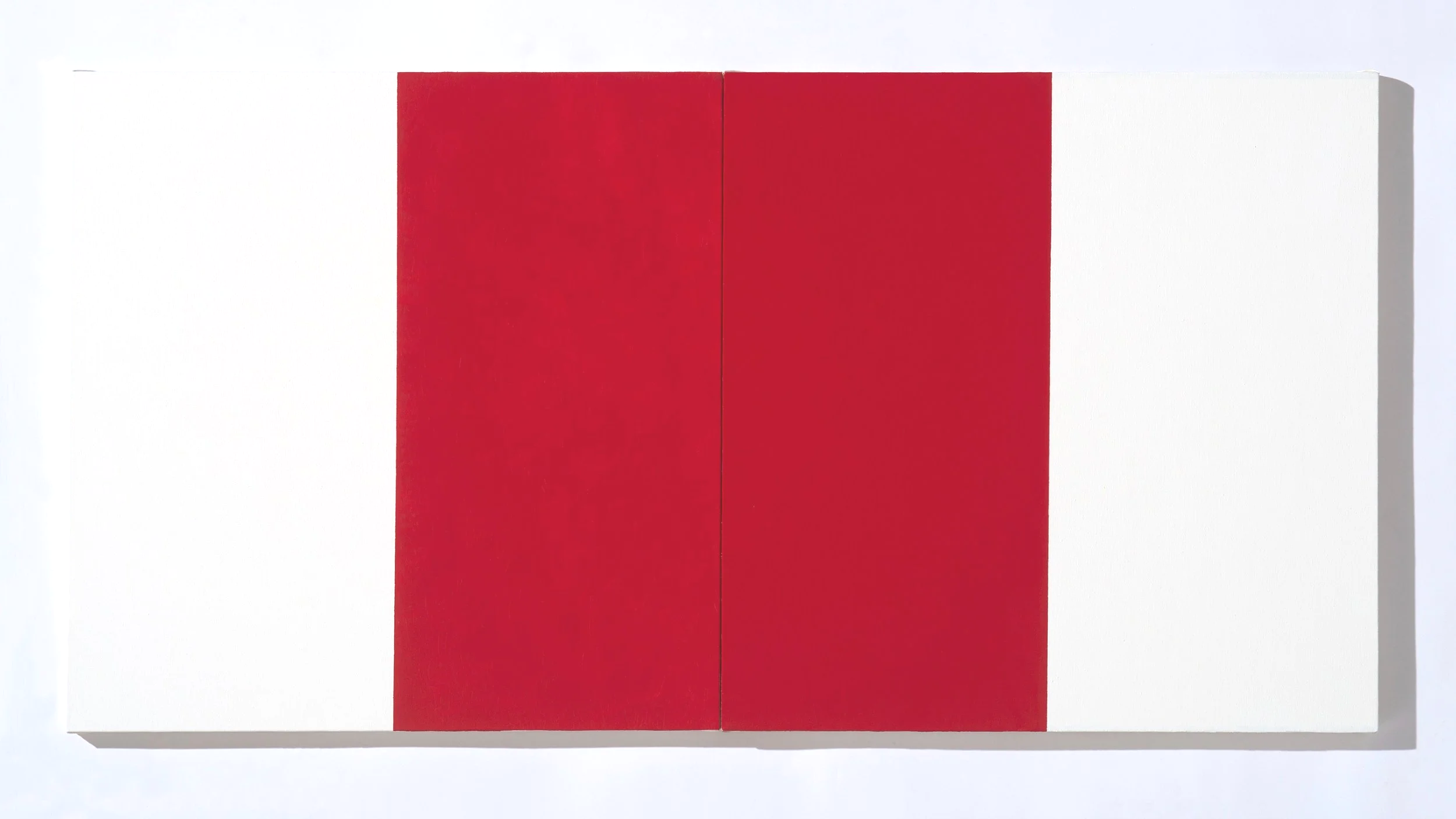 Close-up image of a white rectangular block with a red rectangle in the center, casting a shadow on the right side.